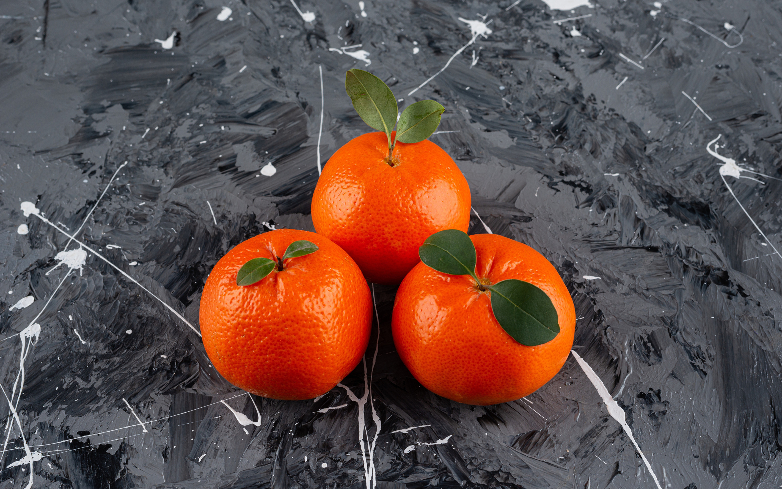 Три мандарина на сером столе