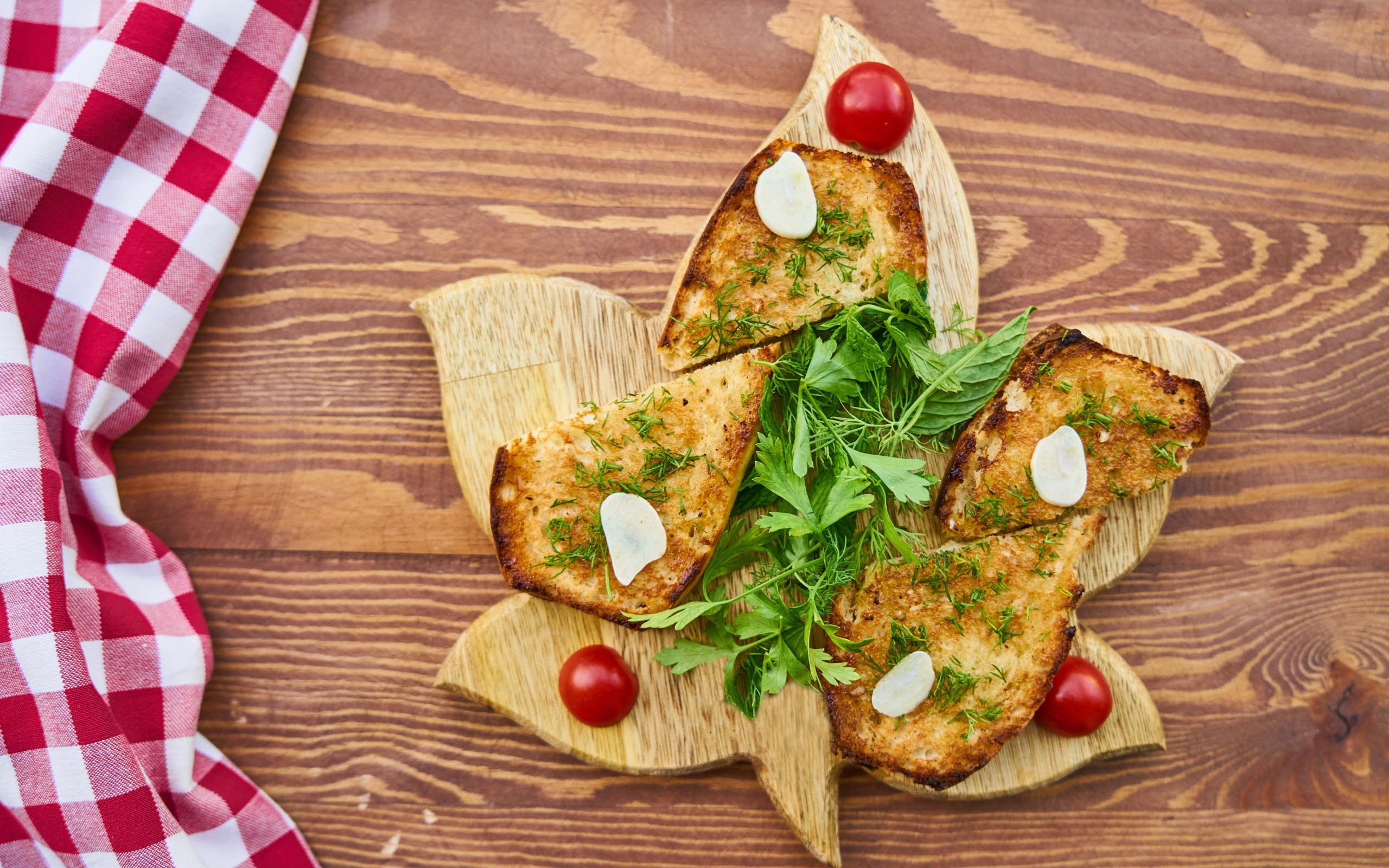 Жареный хлеб на доске с зеленью и помидорами