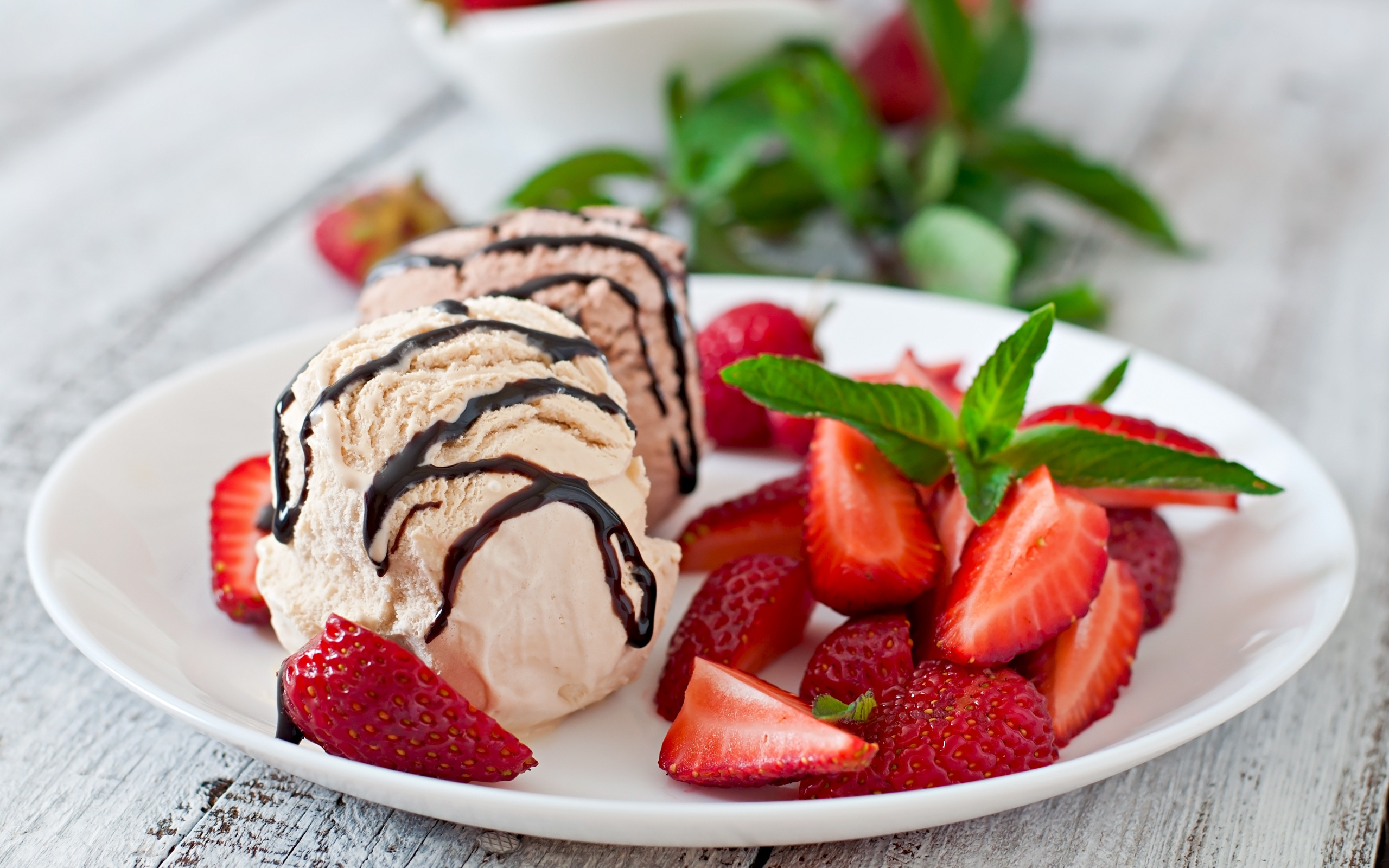 Шарики мороженого на тарелке с кусочками клубники