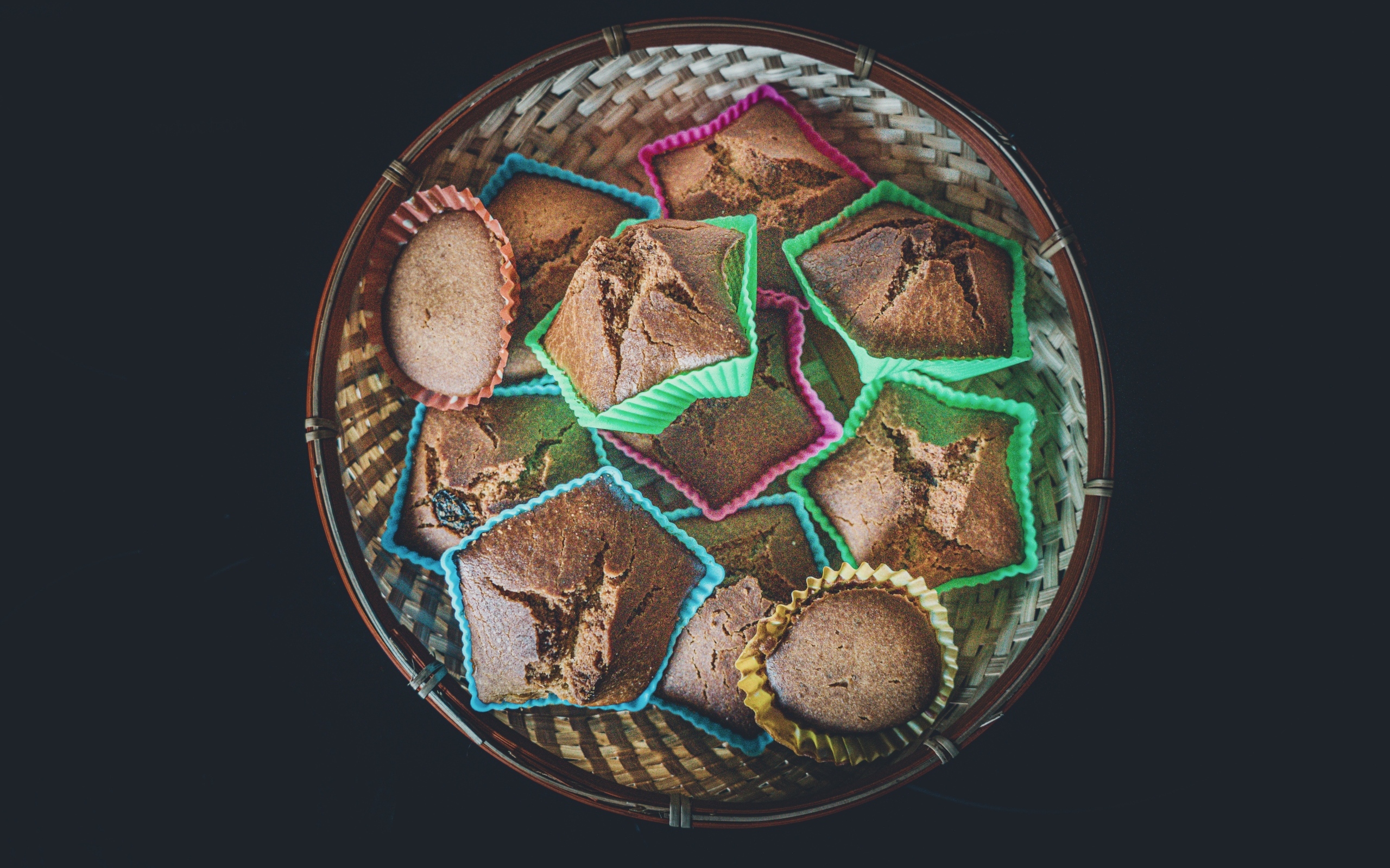 Много кексов в корзине на черном фоне