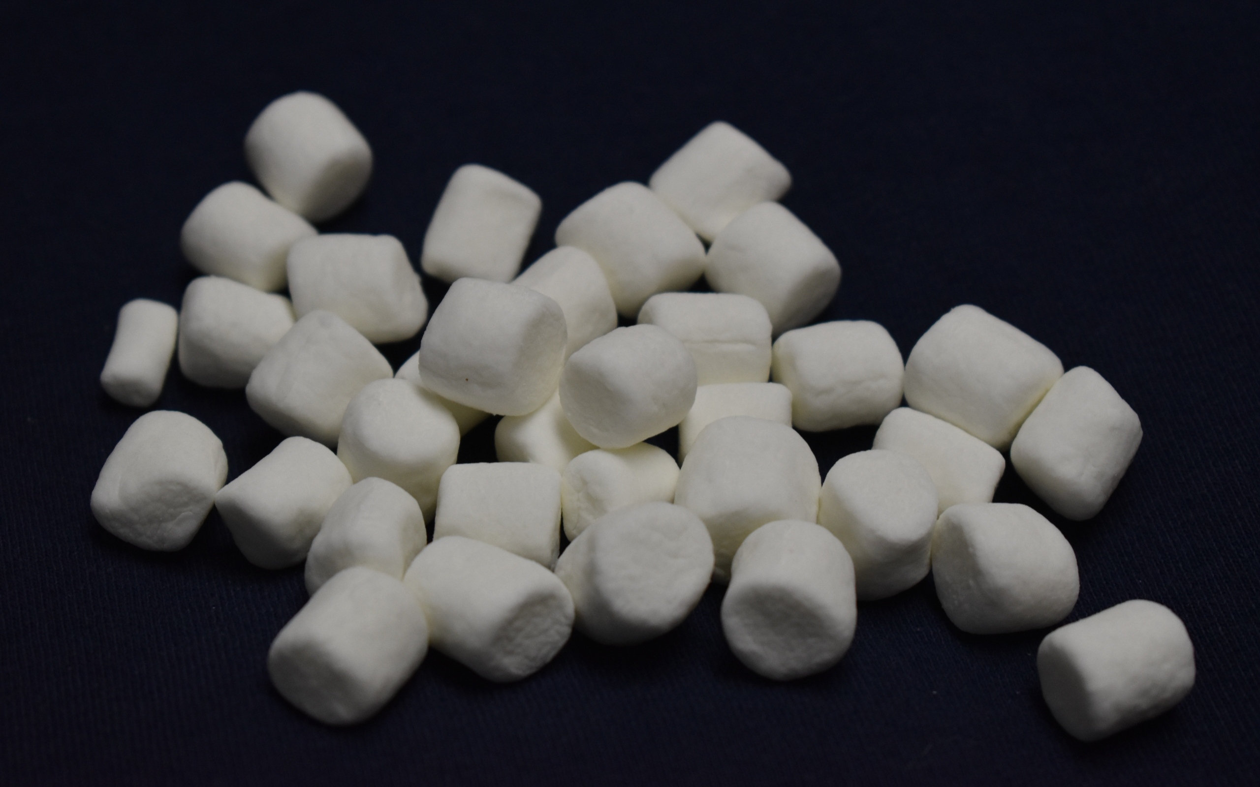 Белое маршмеллоу на черном фоне