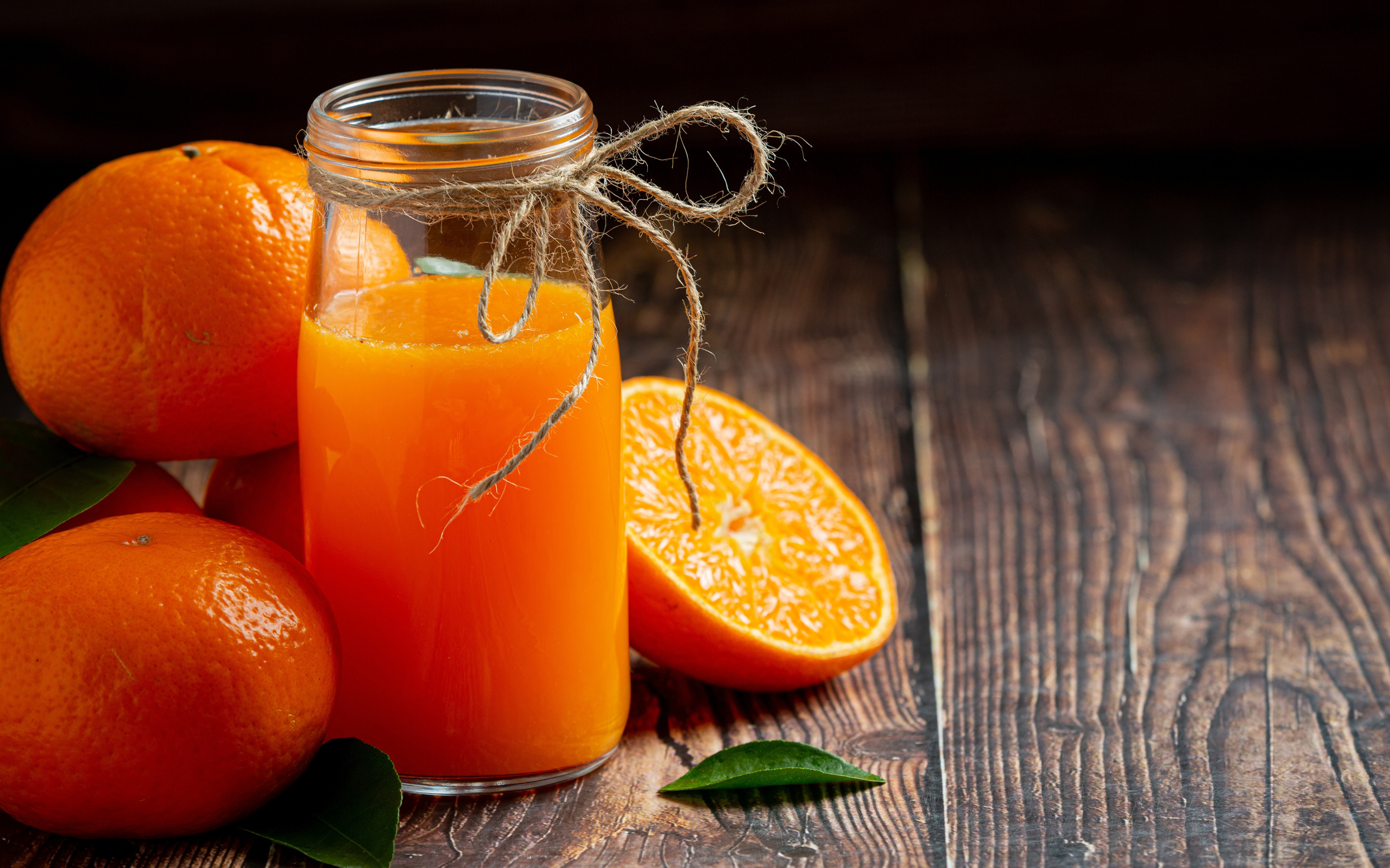 Банка свежего сока на столе с мандаринами