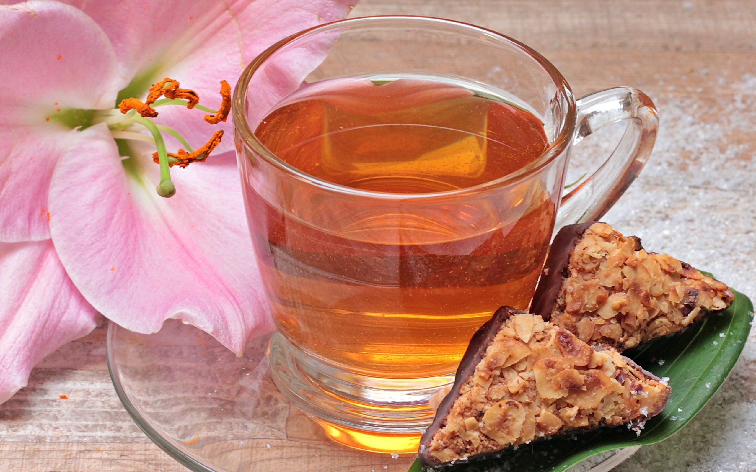 Чай на столе с розовой лилией и конфетами