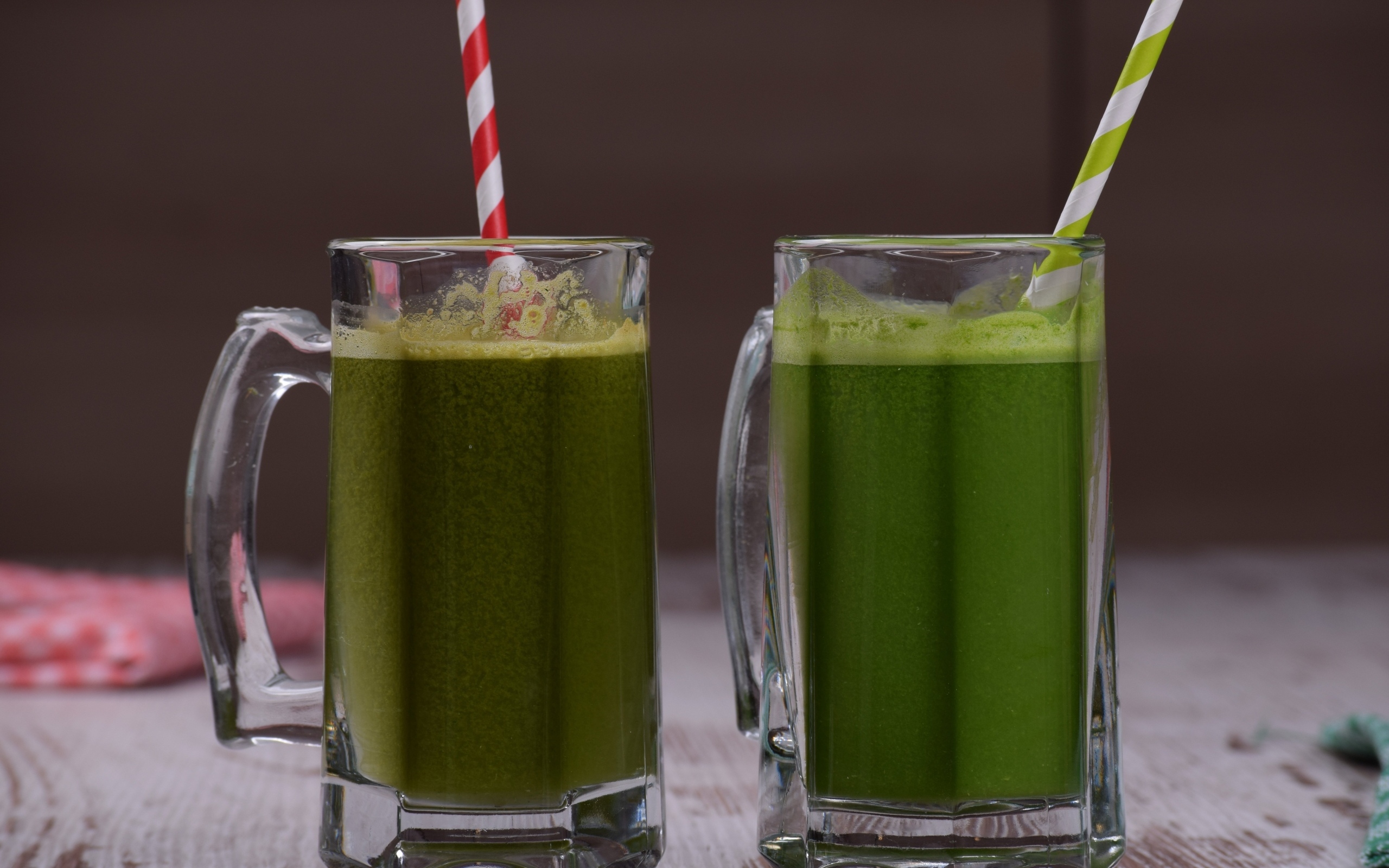 Два стакана зеленого смузи с трубочками