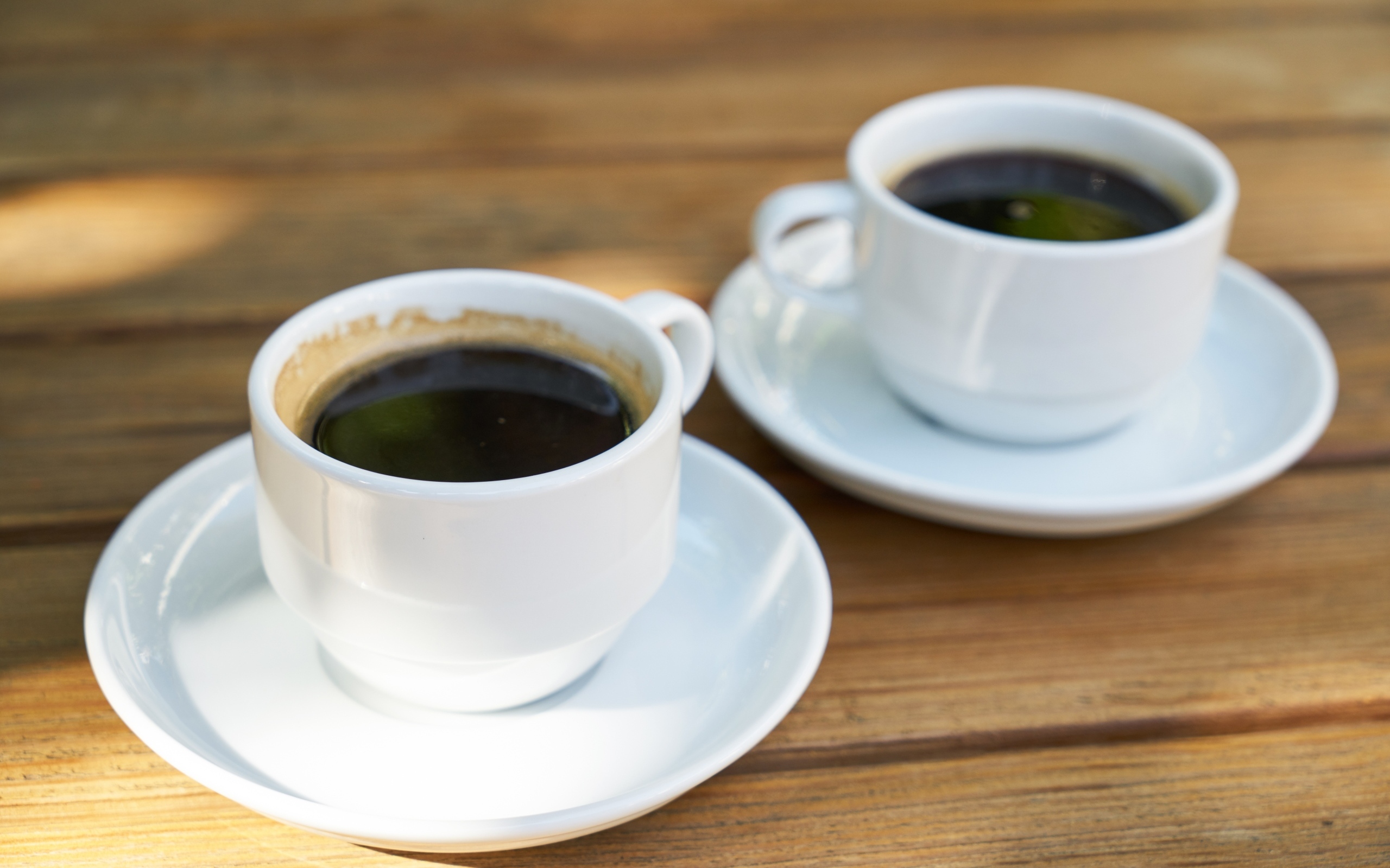 Две белые чашки кофе на столе 