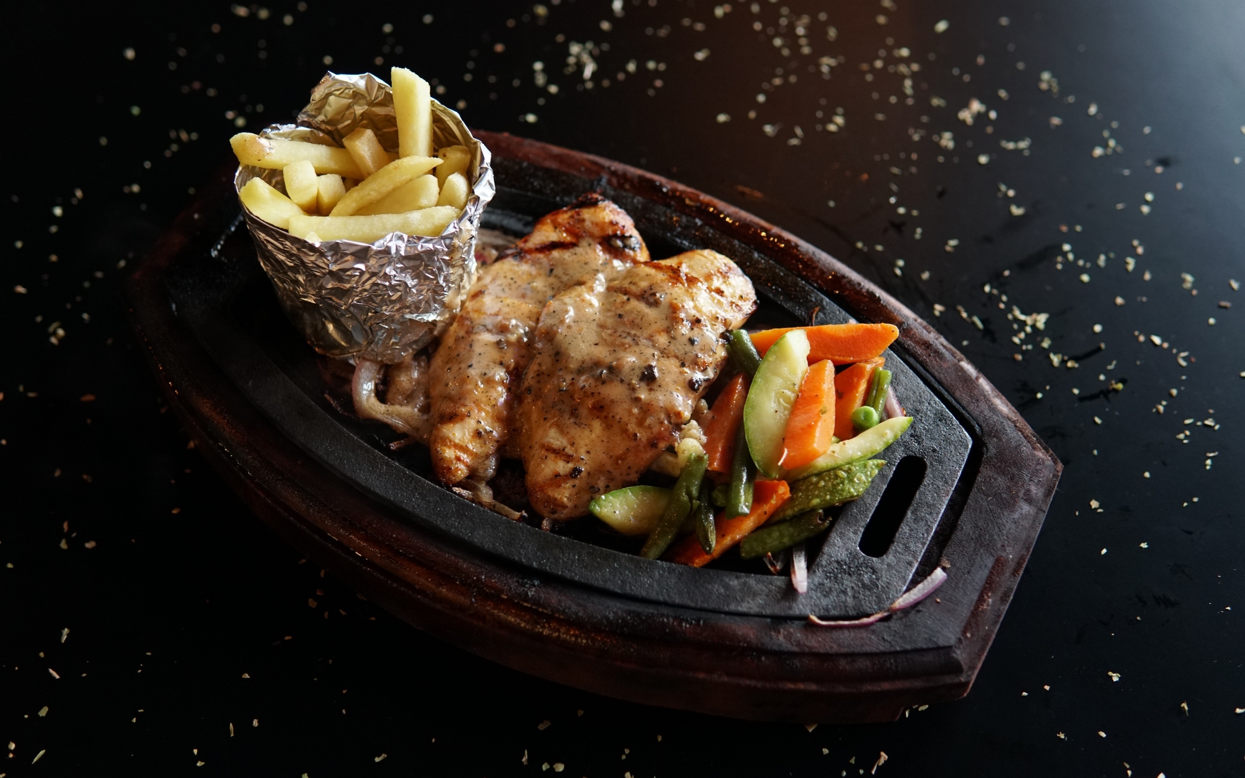 Жареная курица с картофелем фри и салатом на тарелке