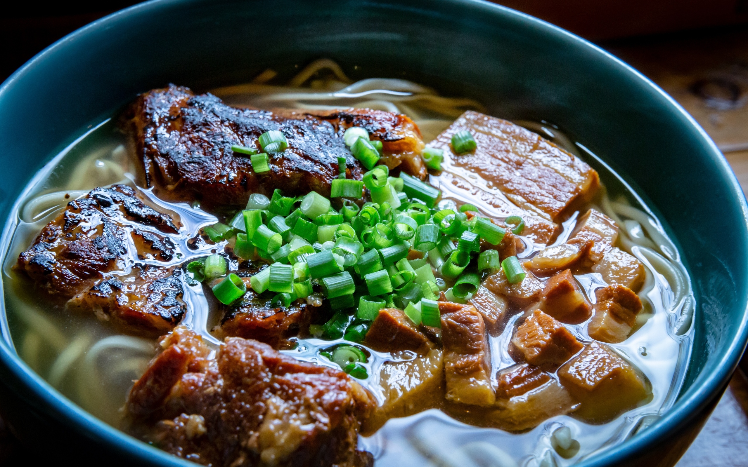 Лапша с мясом и зеленым луком в тарелке