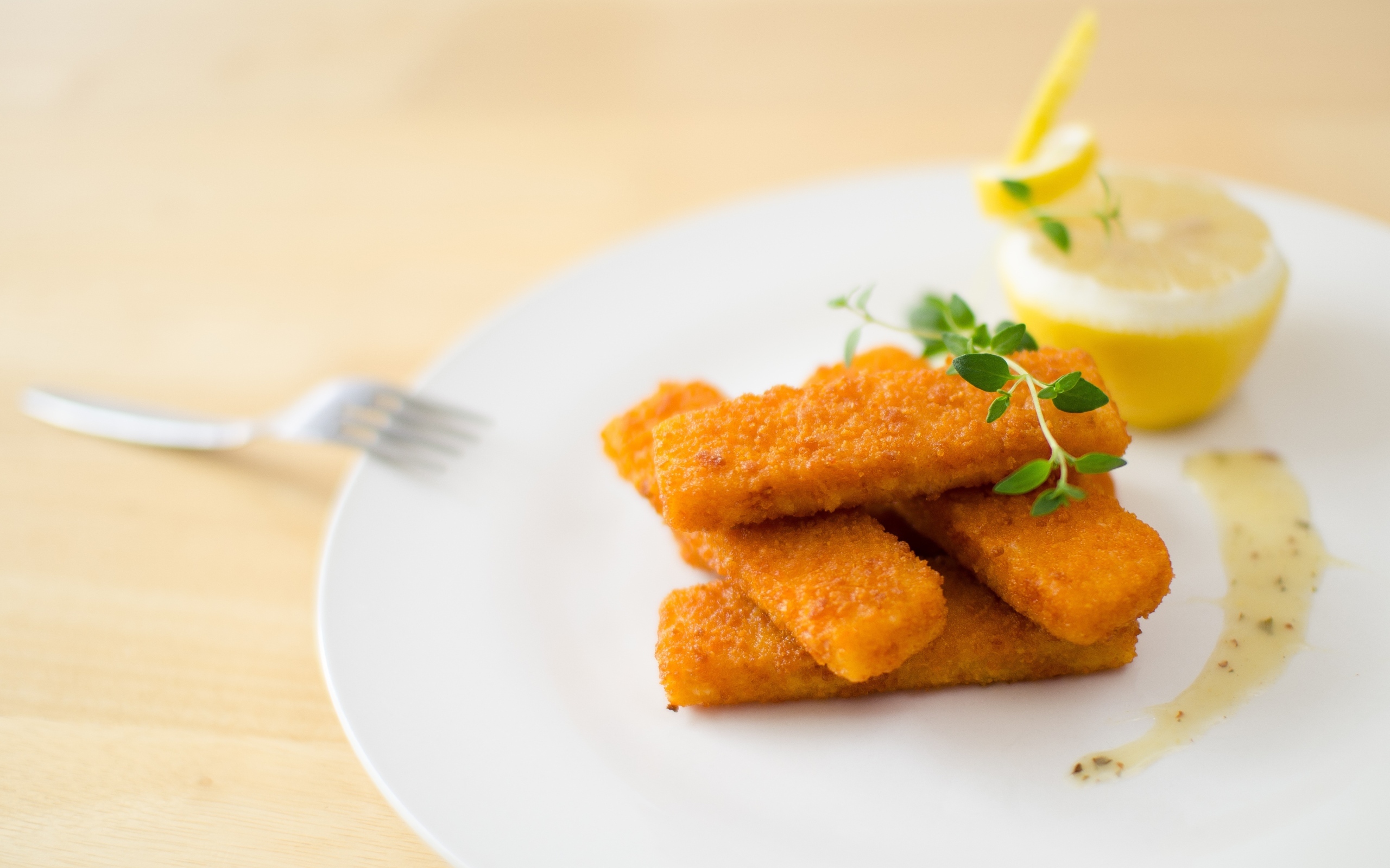 Жареные рыбные палочки на тарелке с лимоном