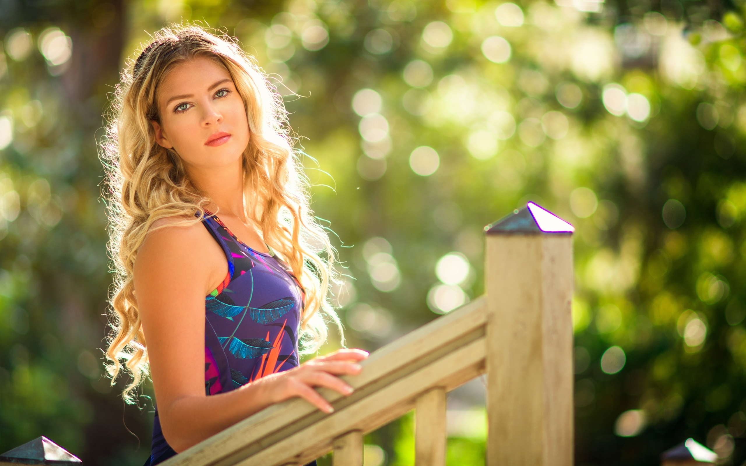 Красивая блондинка стоит у перил