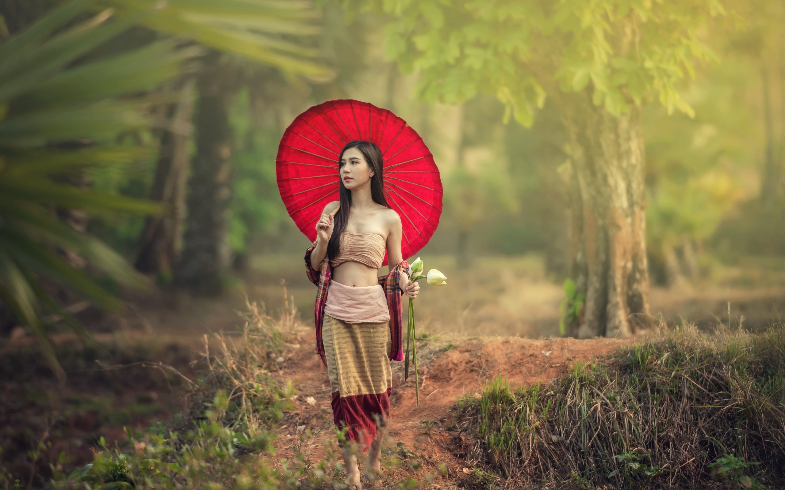 Девушка азиатка с красным зонтом и цветами лотоса
