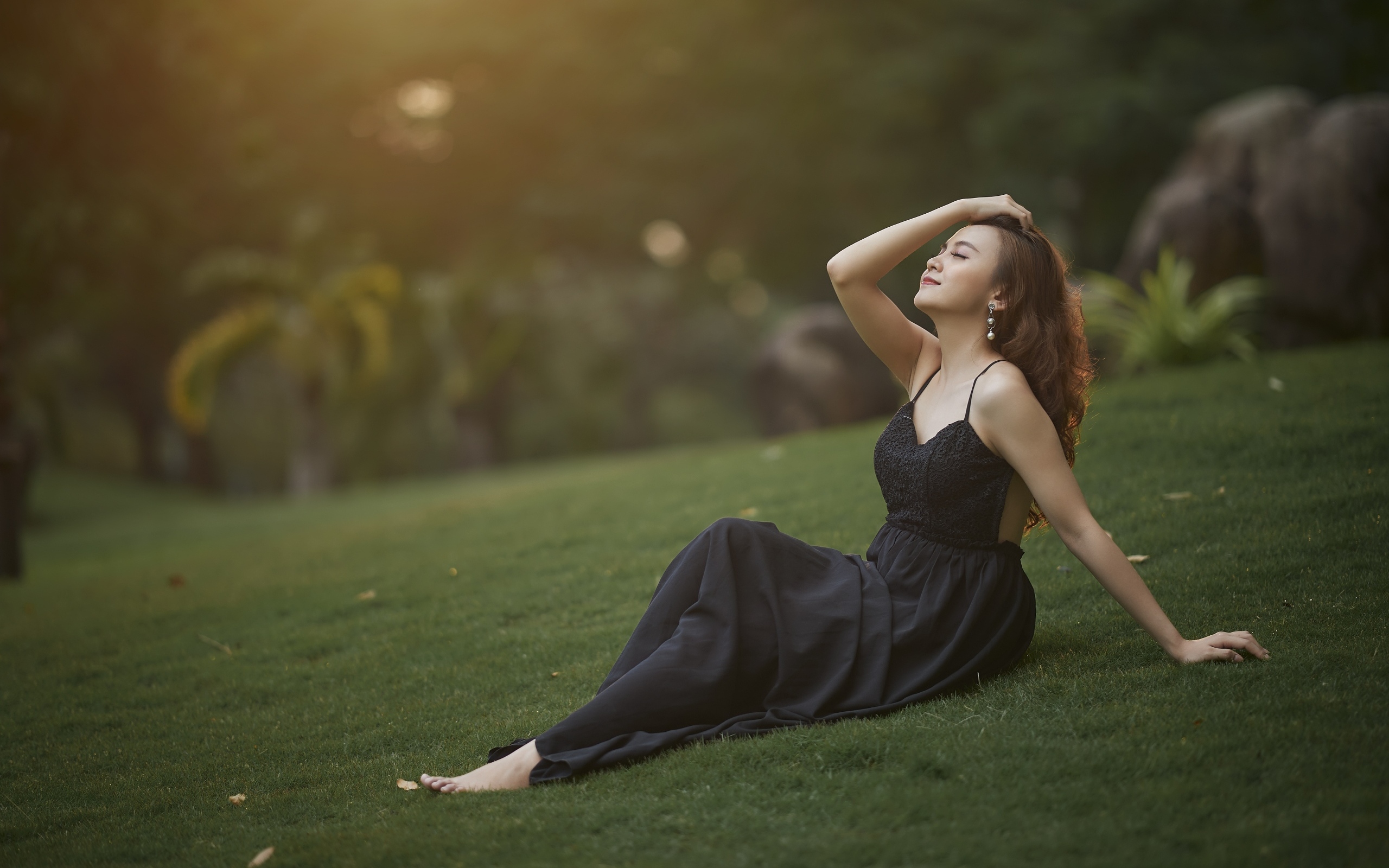 Красивая азиатка с закрытыми глазами в черном платье