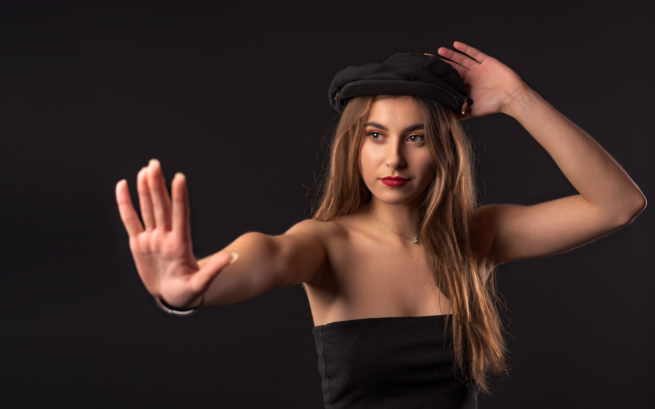 Красивая девушка в кепке на черном фоне