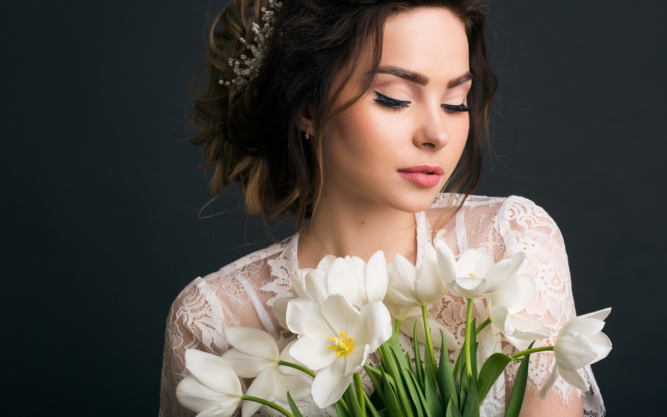 Красивая девушка с букетом белых тюльпанов на сером фоне