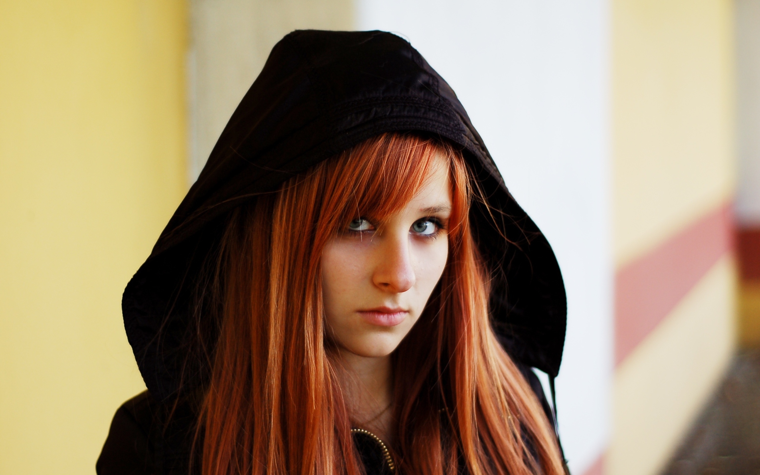 Красивая рыжеволосая девушка в черном балахоне