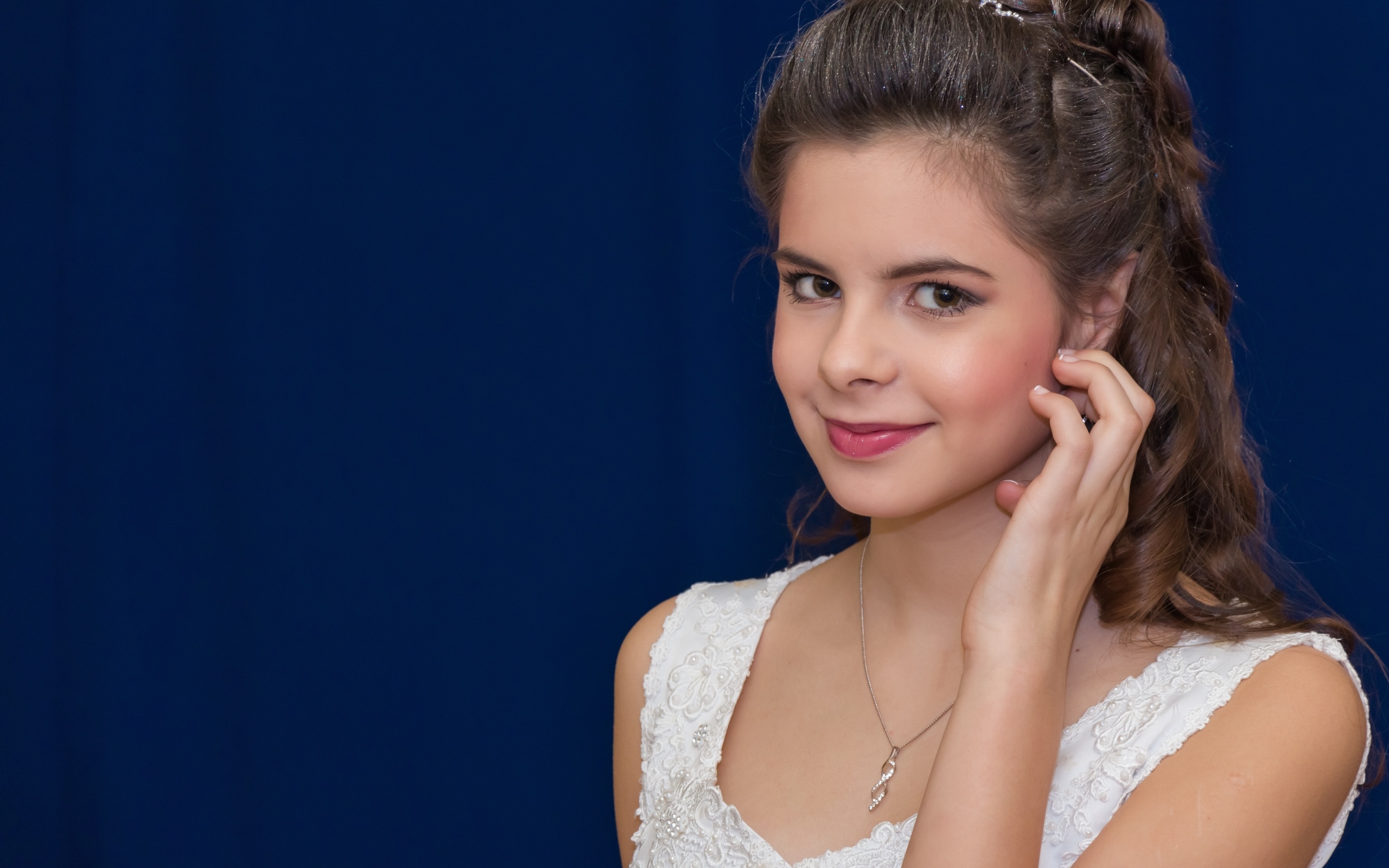 Милая девушка в белом платье на синем фоне