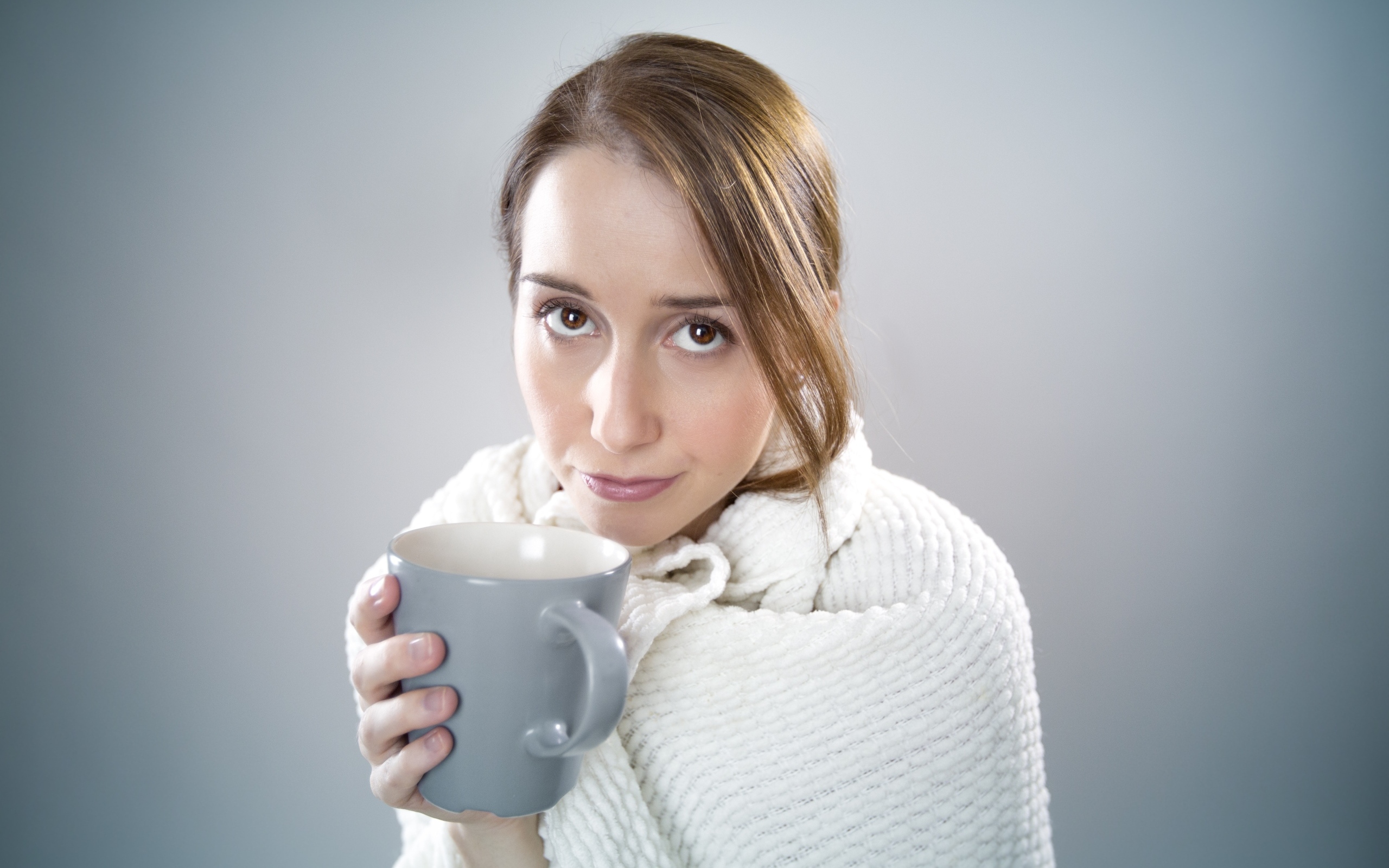 Девушка в белой кофте с кружкой в руке