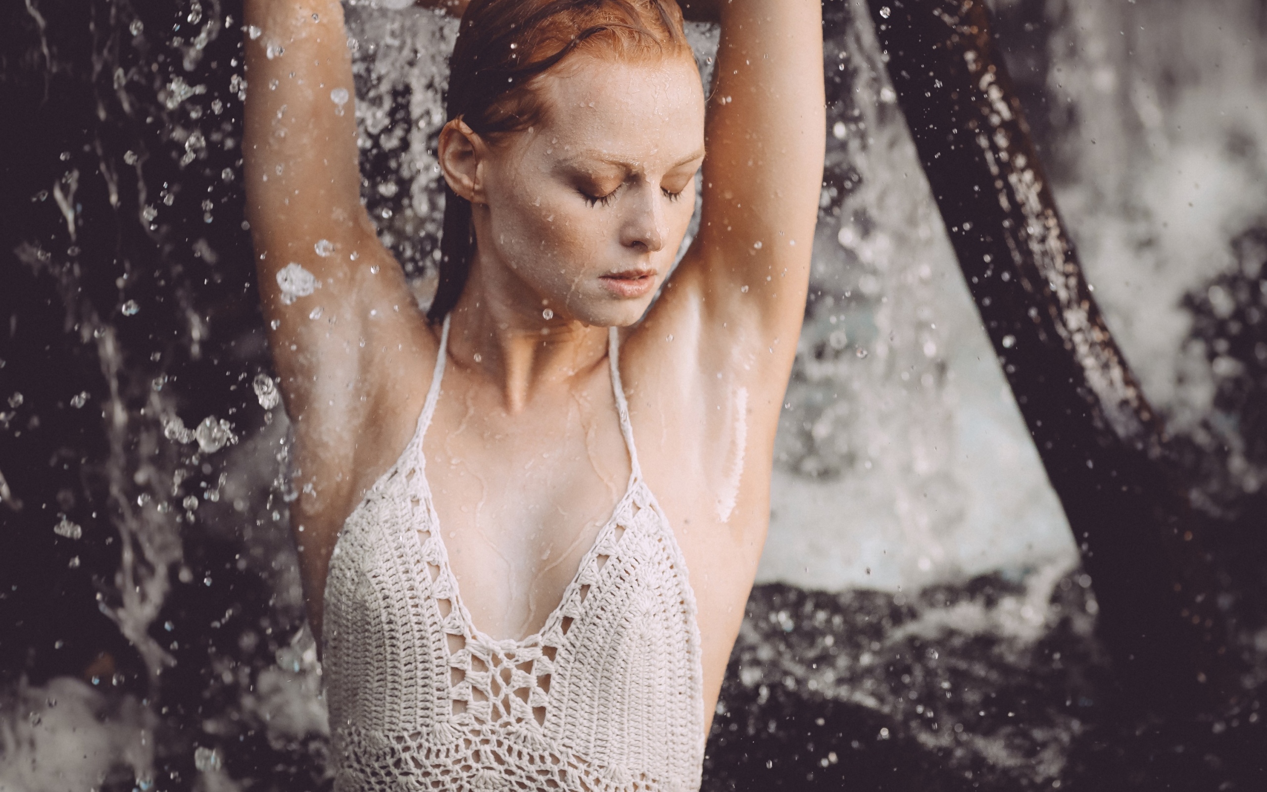 Рыжеволосая девушка в брызгах воды