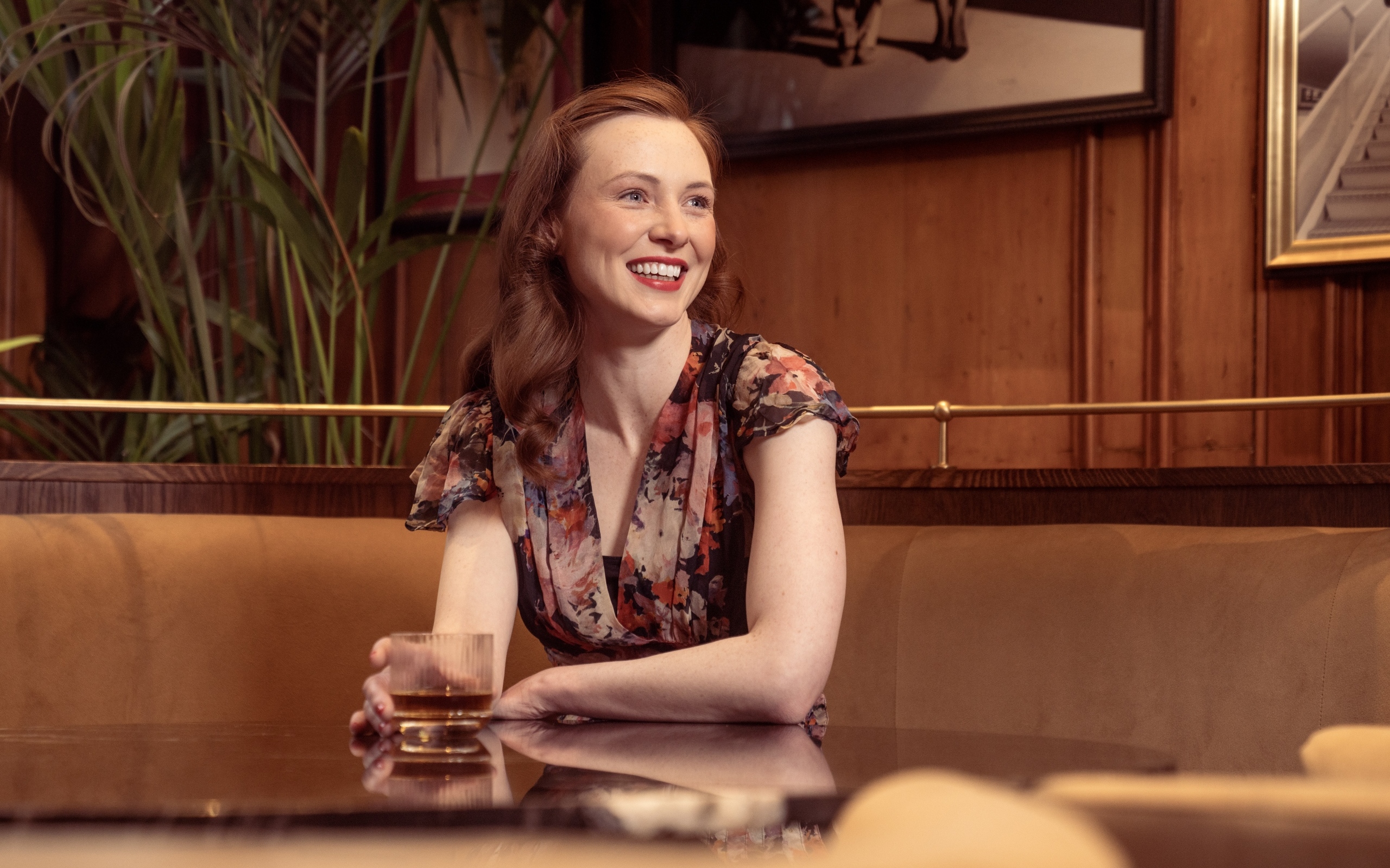 Улыбающаяся девушка за столиком в кафе