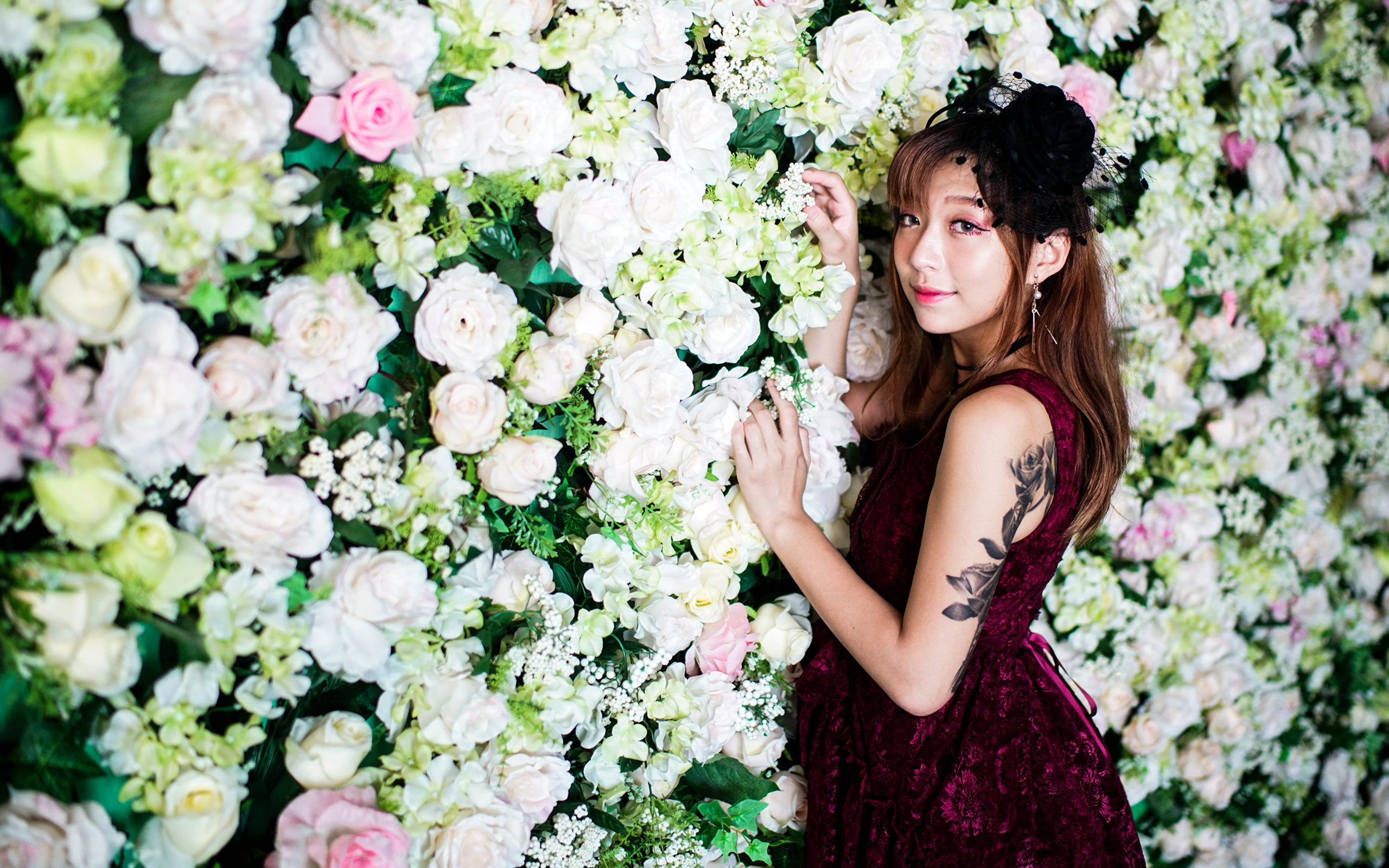 Молодая азиатка на фоне стены с розами