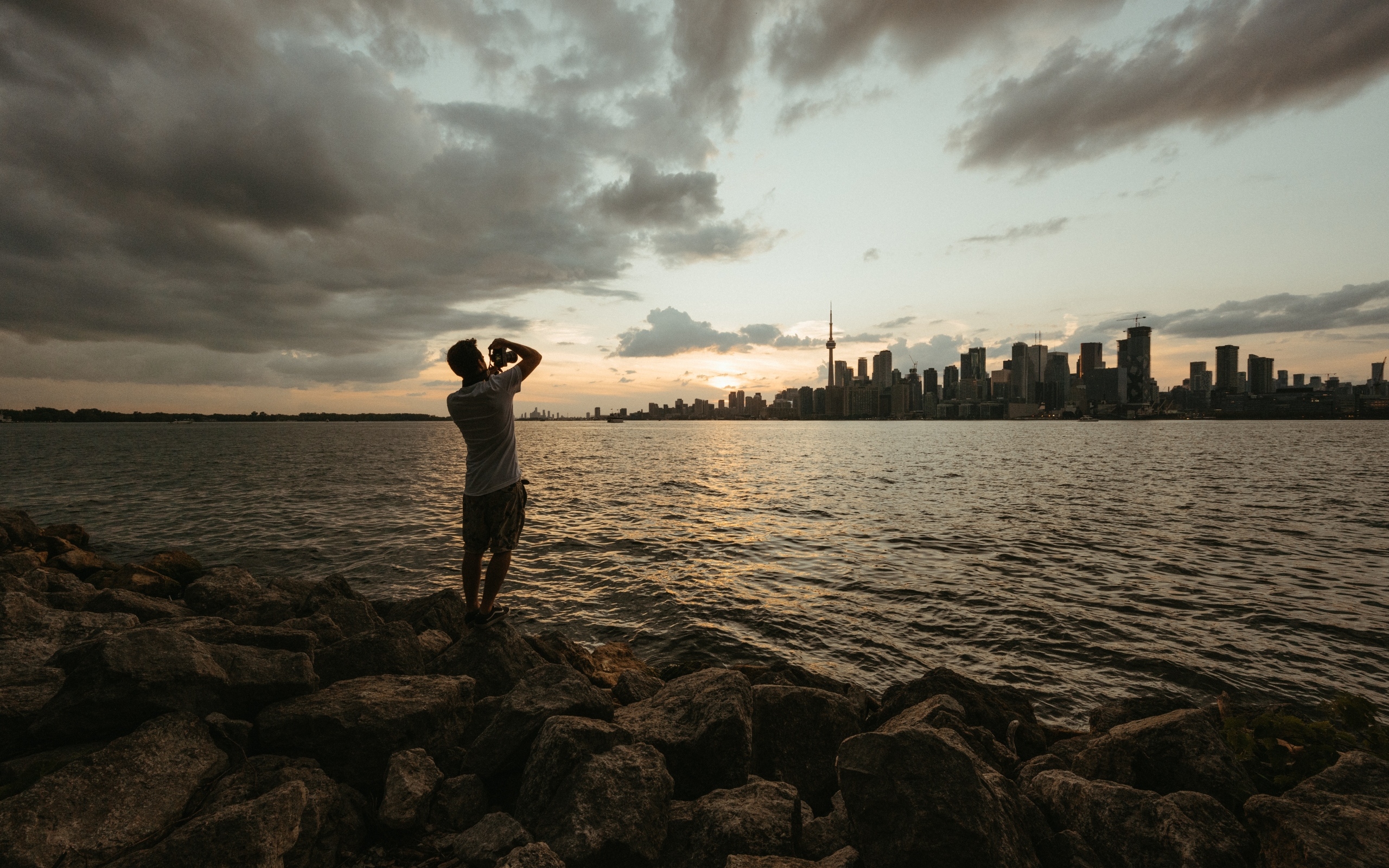 Мужчина делает фото города у моря