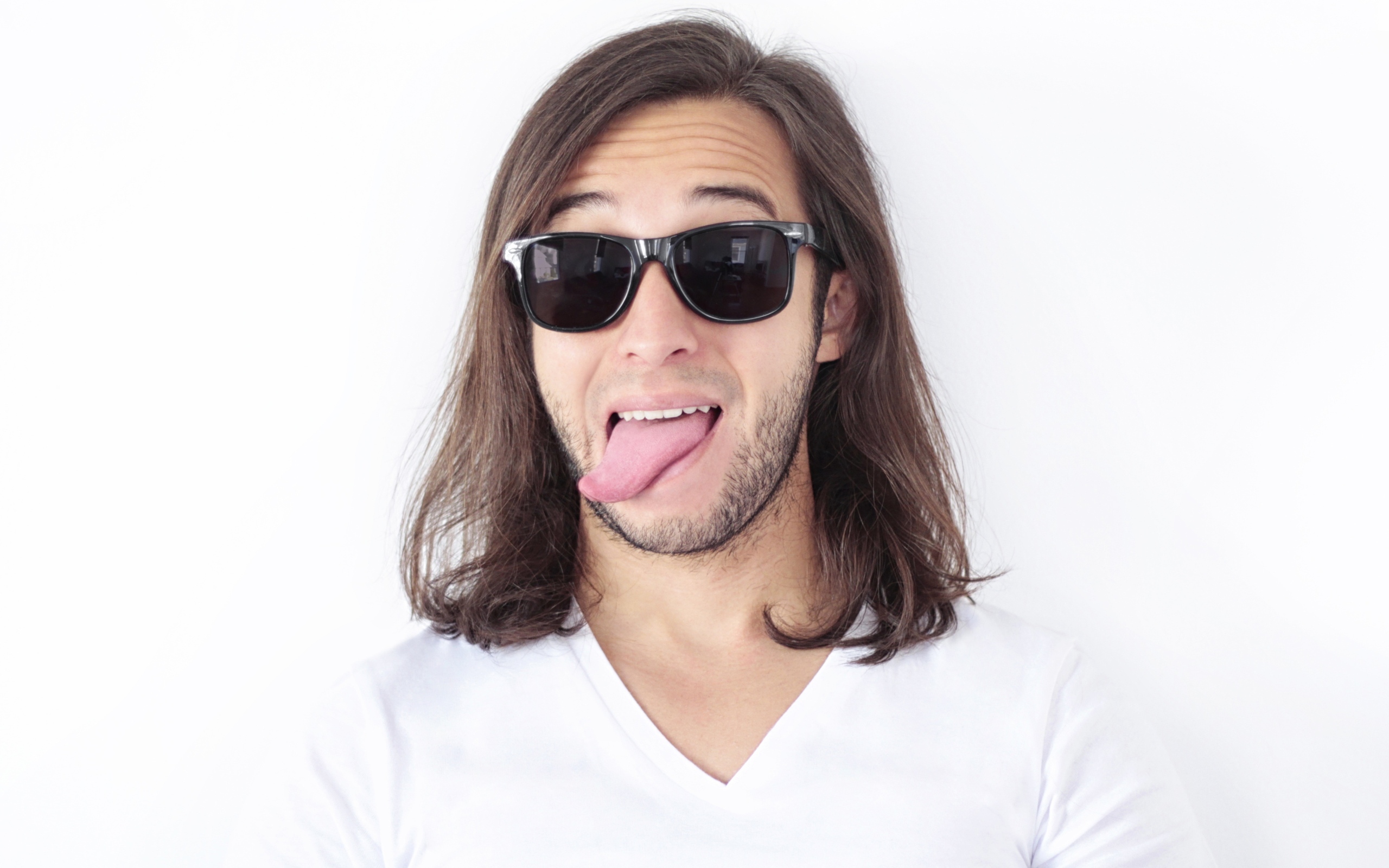 Мужчина в очках с высунутым языком