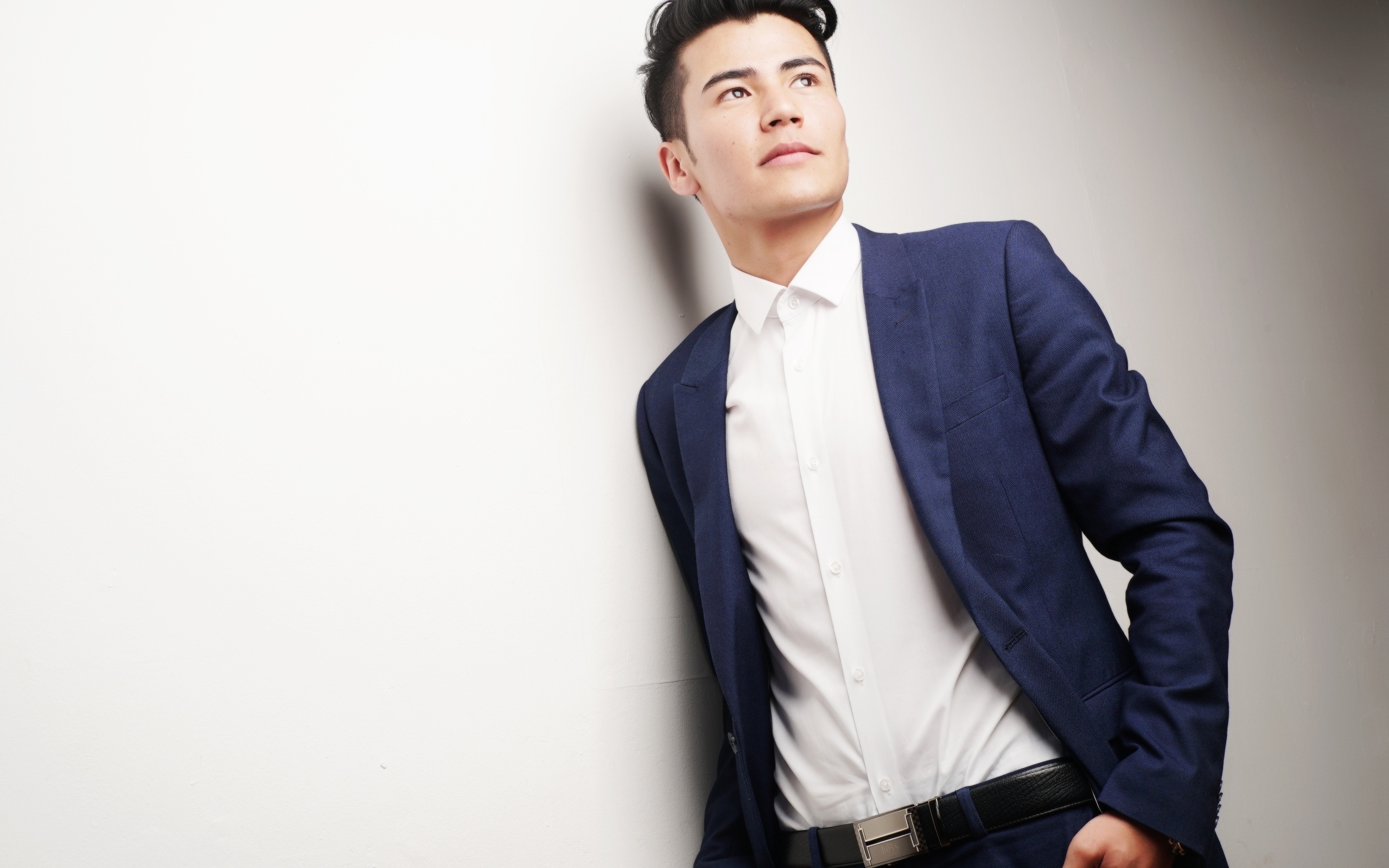 Молодой мужчина в костюме у стены