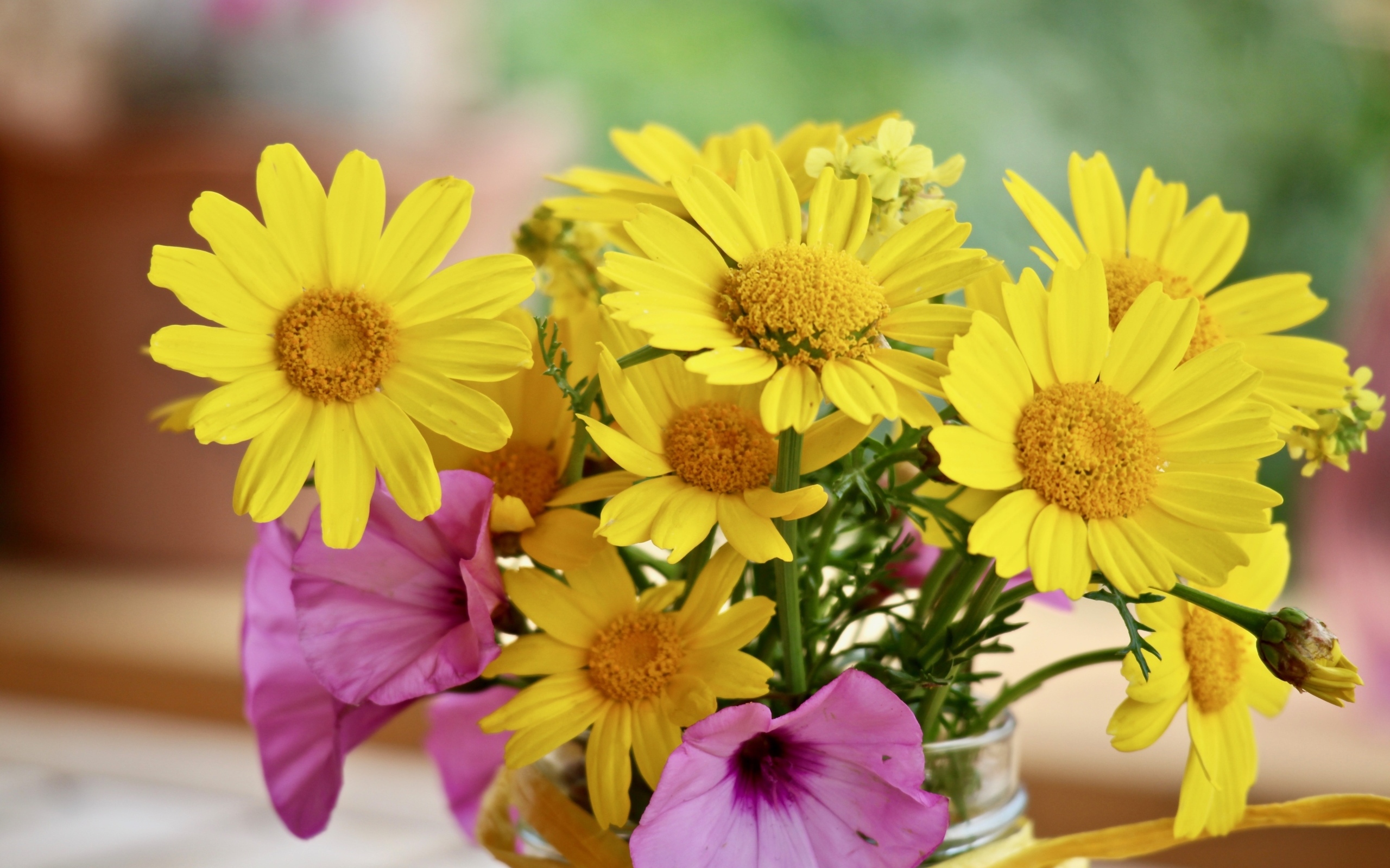 Букет желтых и розовых цветов в вазе на столе