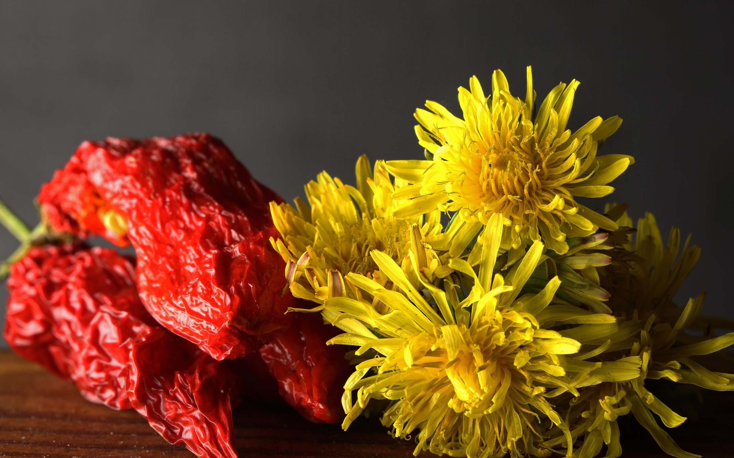 Желтые одуванчики с красным перцем на столе