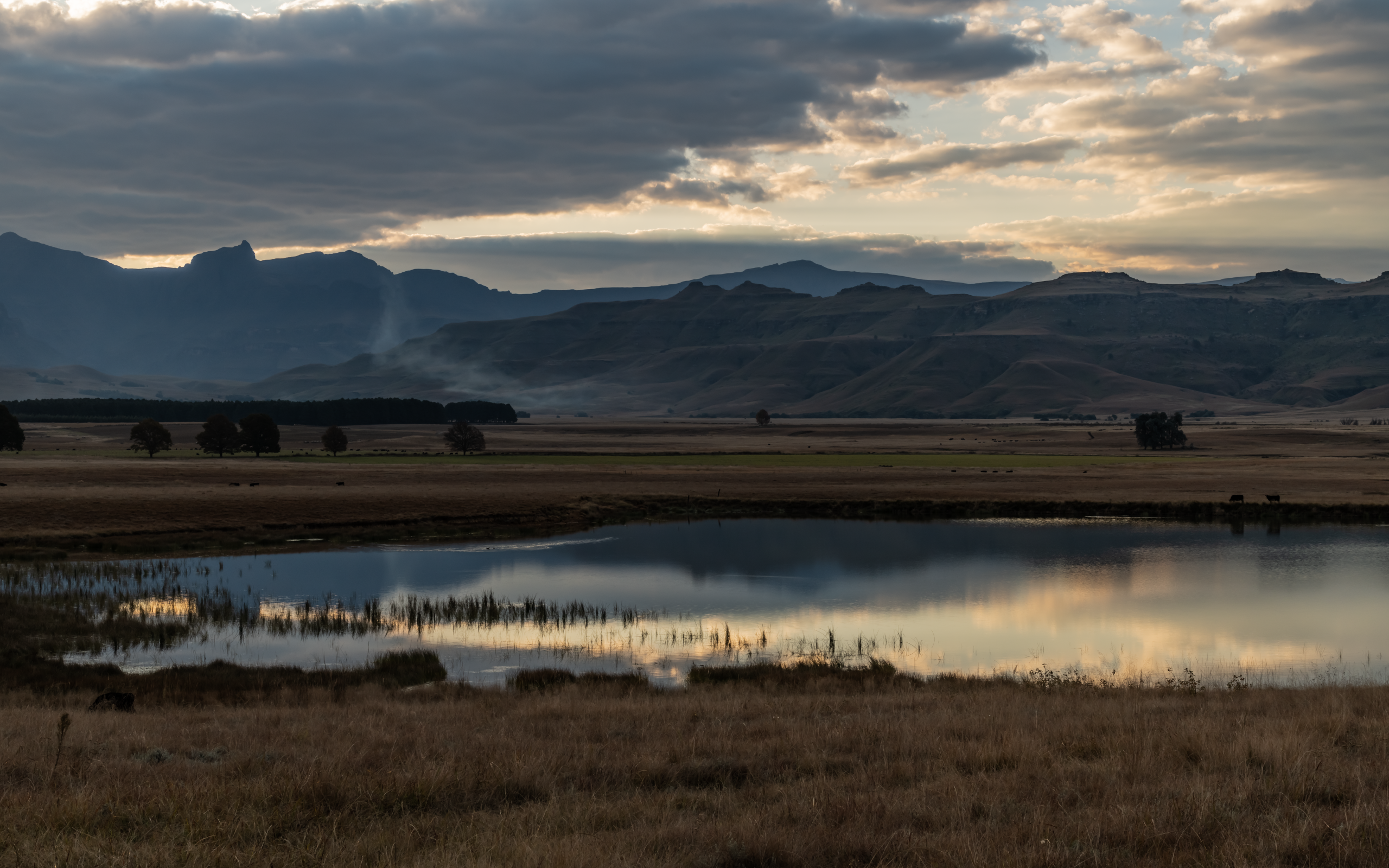 Грозовые облака отражаются в воде озера в горах 