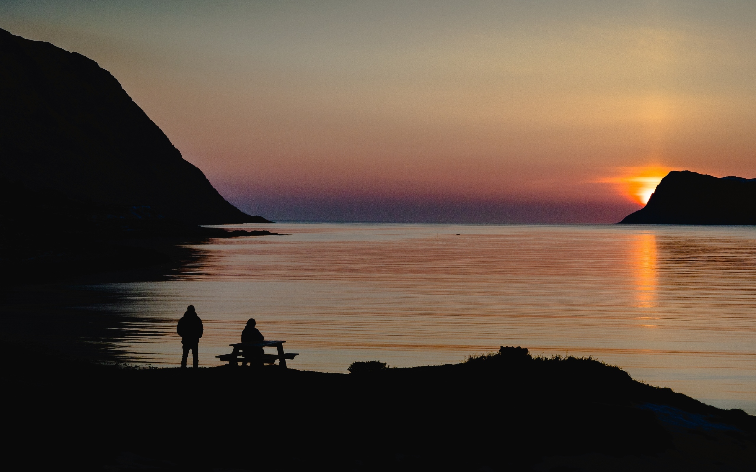 Солнце скрывается за горой в заливе