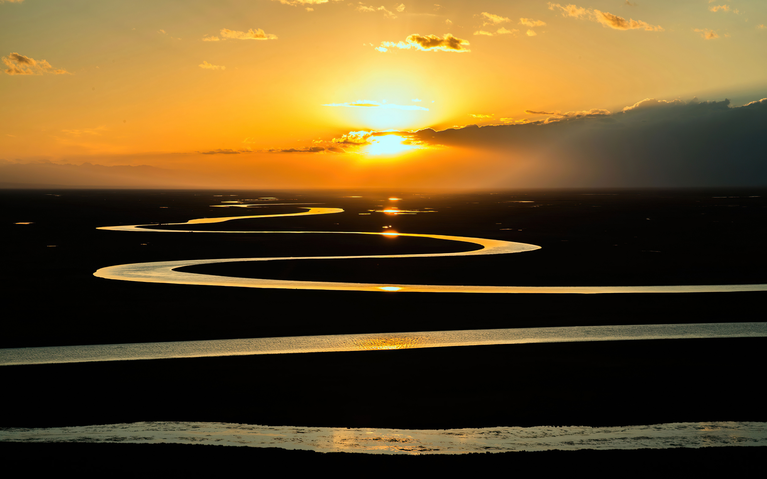 Извилистая река в лучах солнца на закате