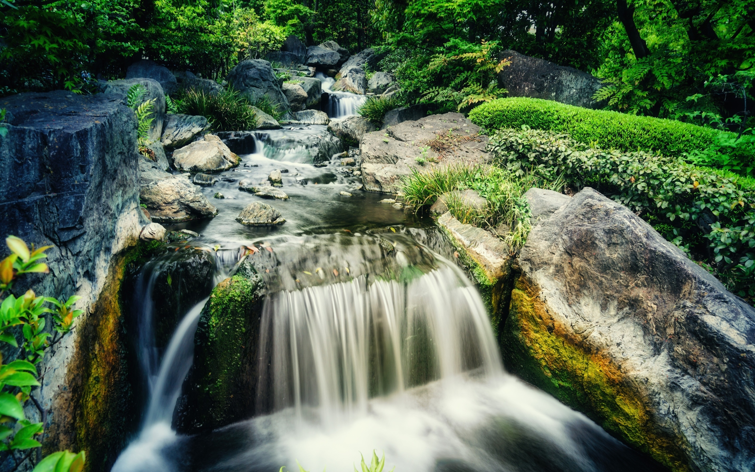 Водопад стекает по камням лесной горной реки