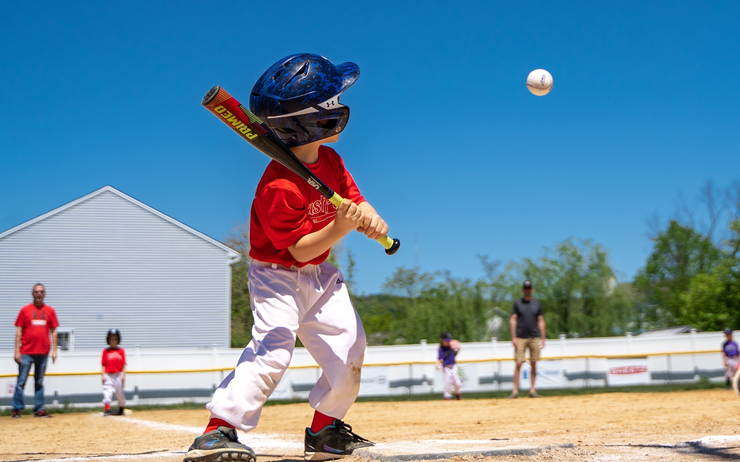 Маленький мальчик играет в бейсбол 