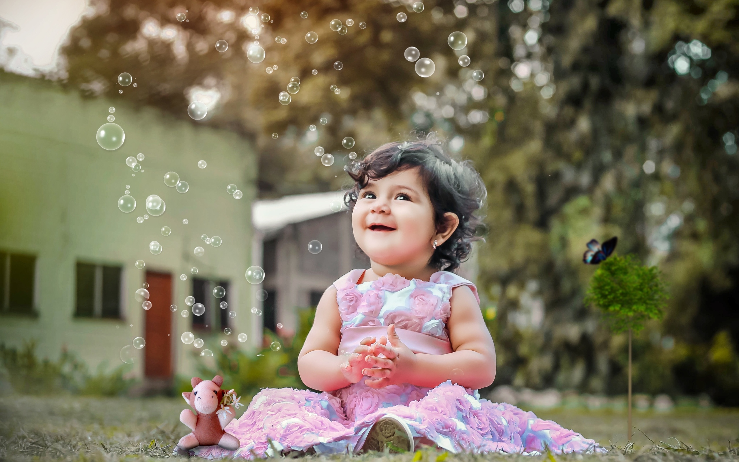 Маленькая девочка радуется мыльным пузырям