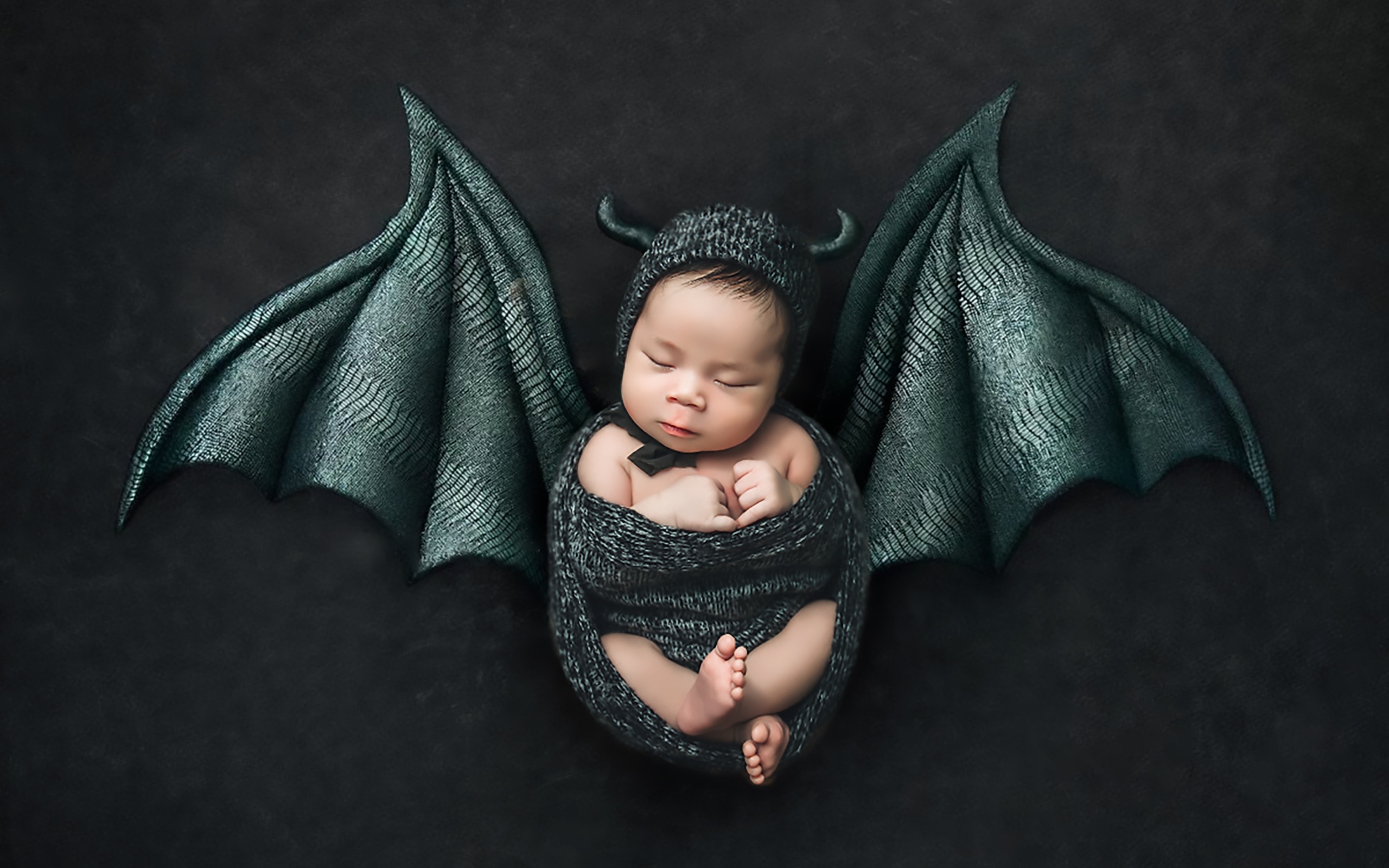 Маленький спящий ребенок с крыльями на Хэллоуин