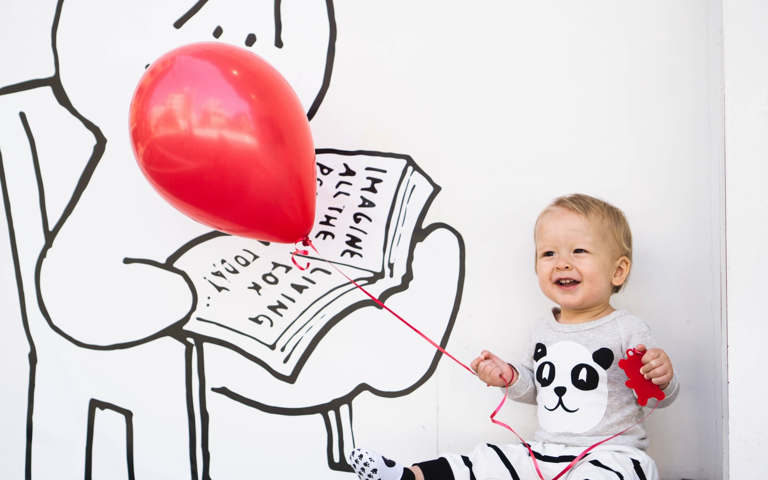 Маленький улыбающийся мальчик с шариком в руках