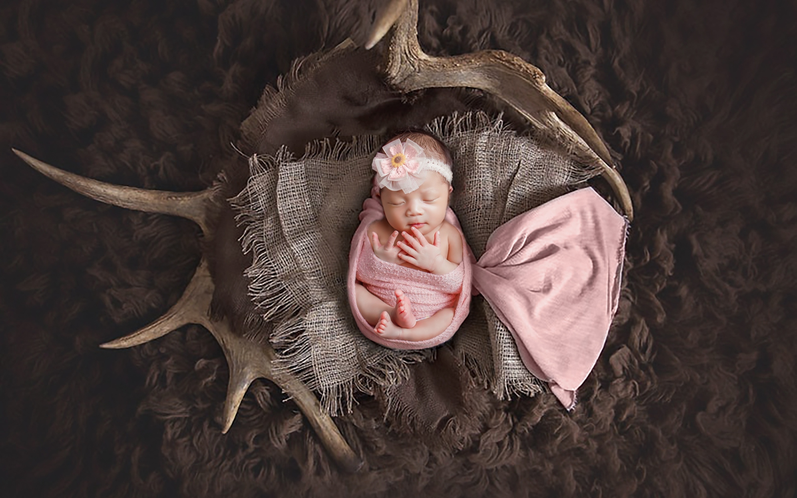 Новорожденная девочка на покрывале с рогами