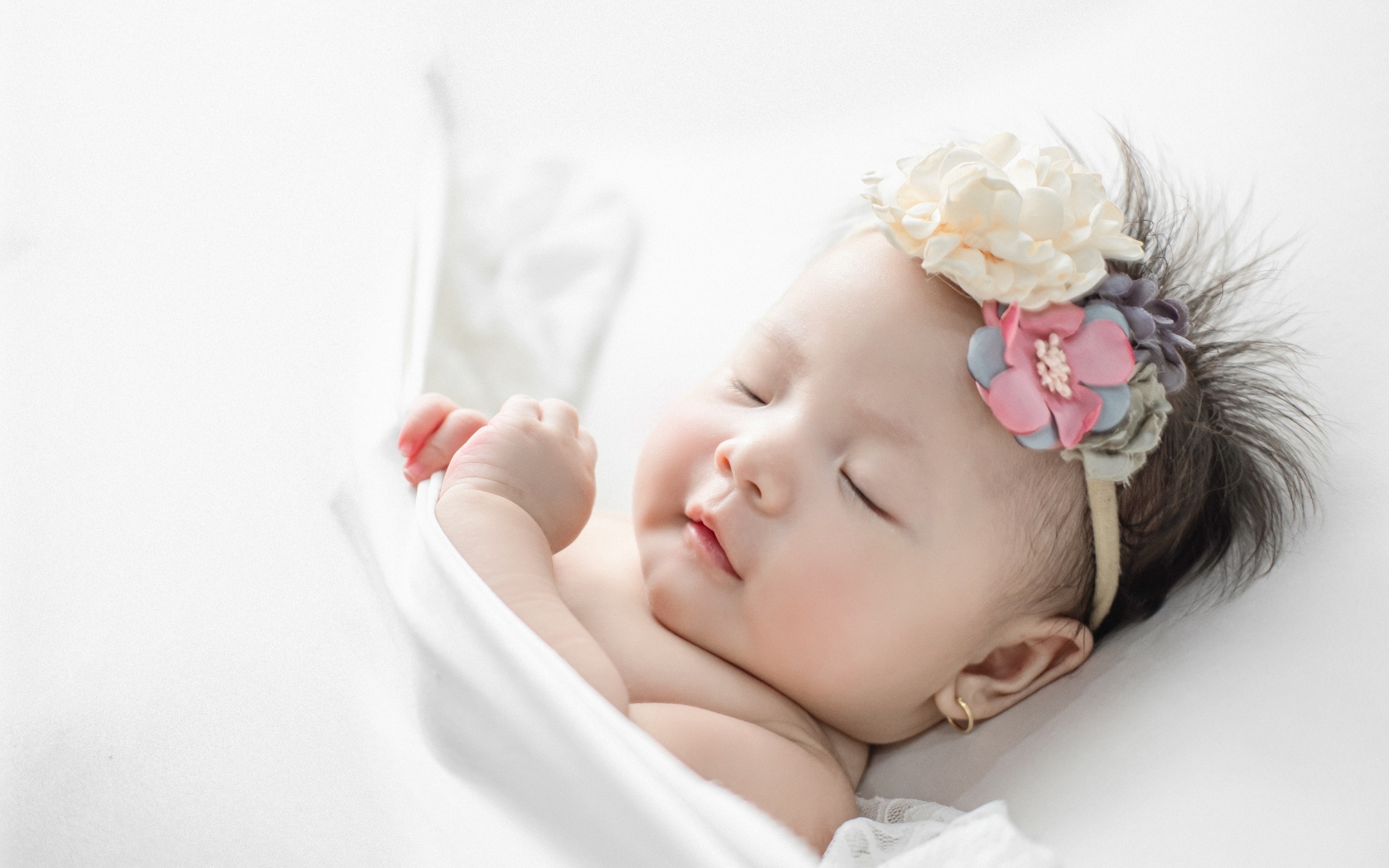 Новорожденная девочка с повязкой на голове