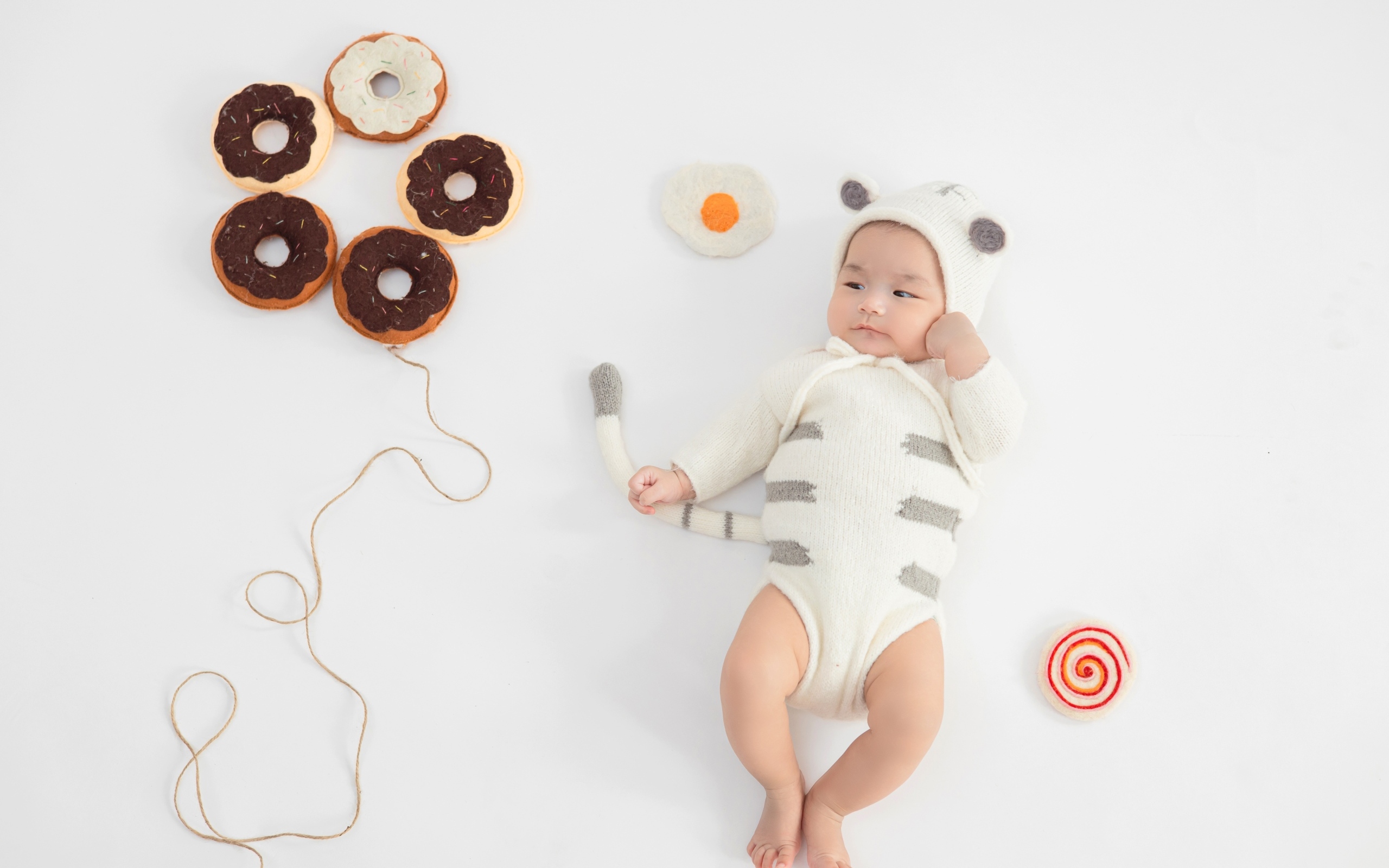 Новорожденный ребенок в костюме с пончиками