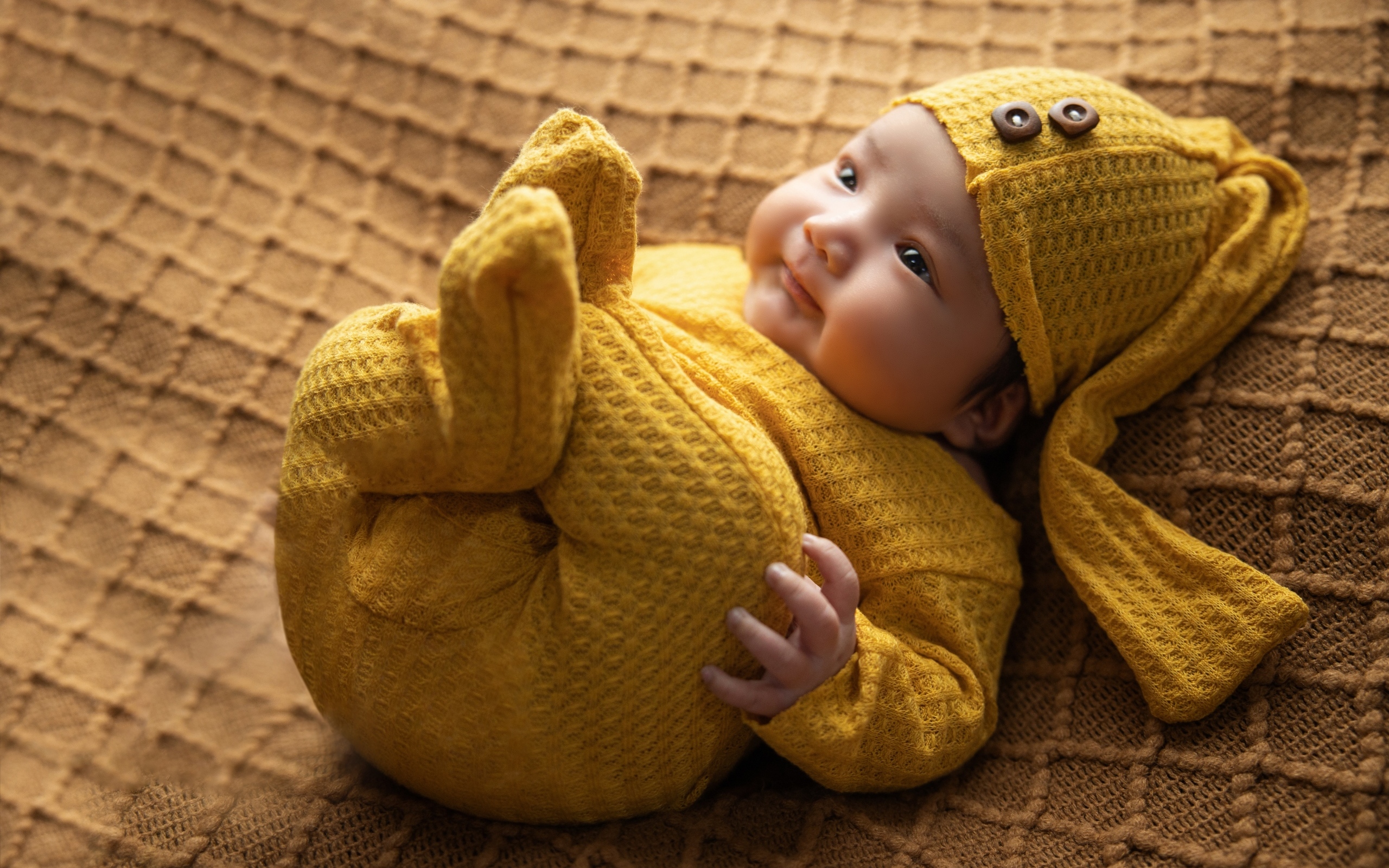 Новорожденный ребенок в желтом костюме 