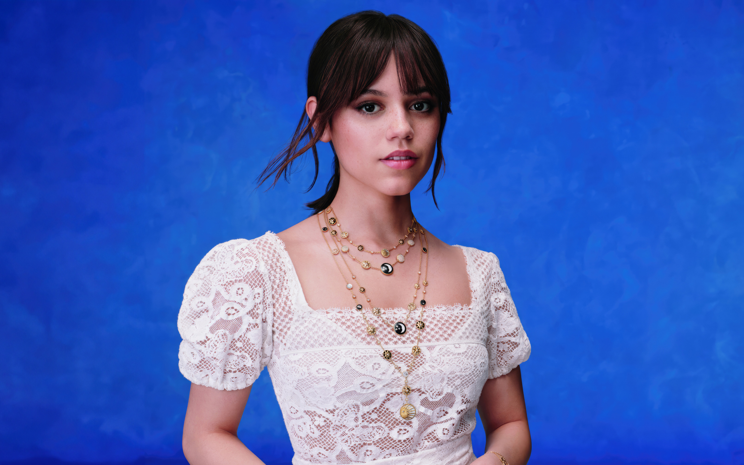 Актриса Дженна Ортега в белом платье на голубом фоне