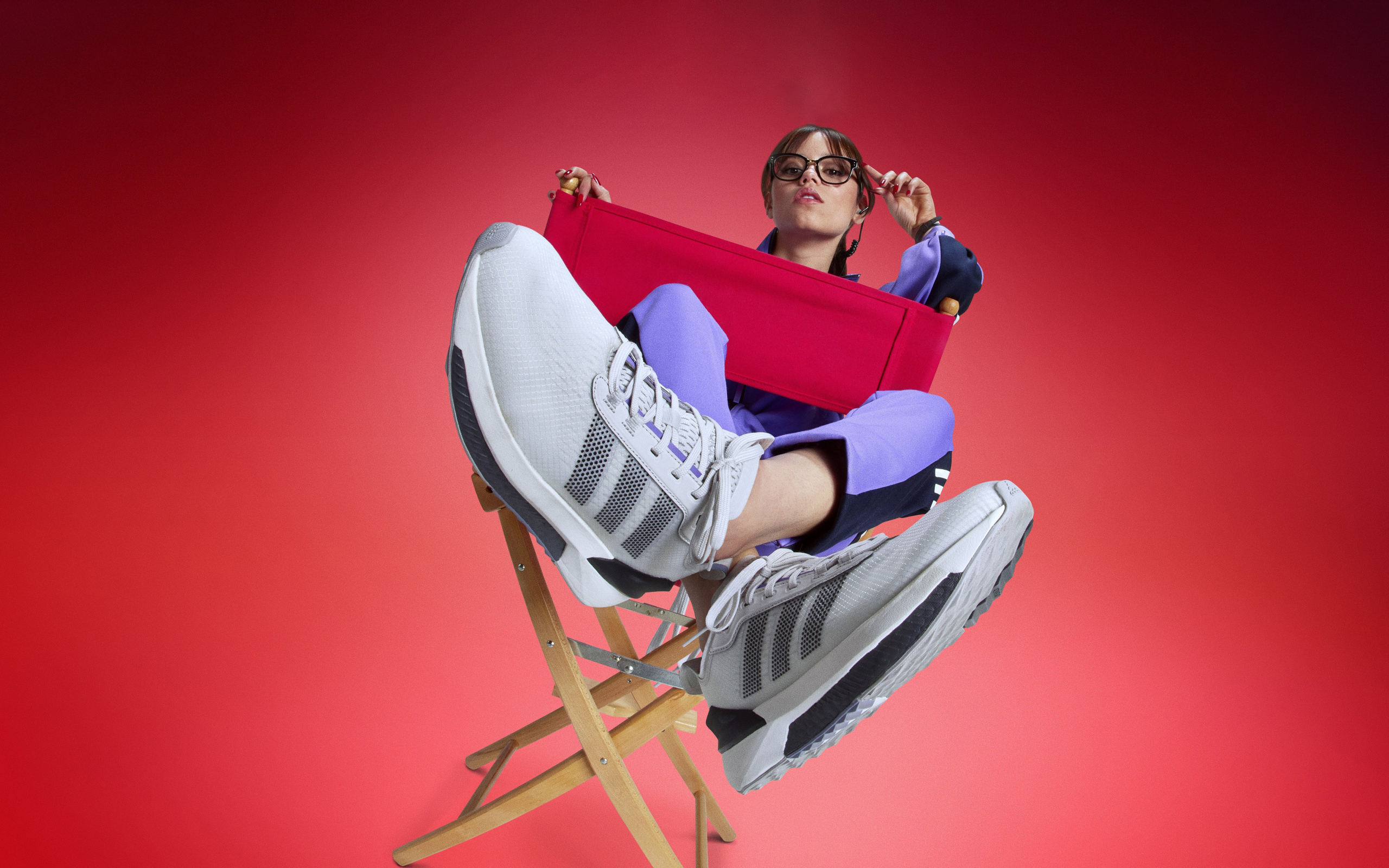 Актриса Дженна Ортега в кроссовках адидас сидит на стуле