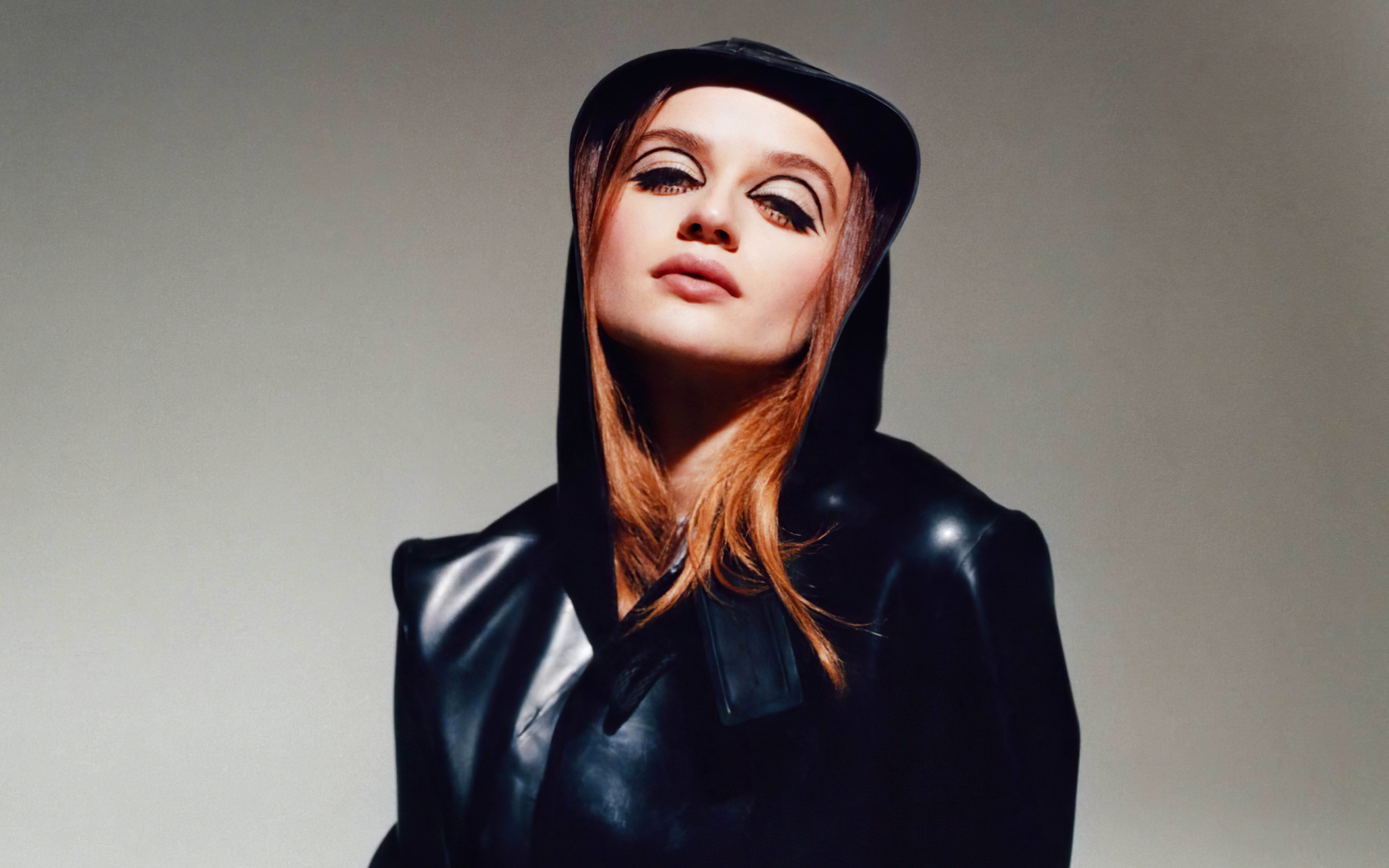 Актриса Джоуи Кинг в черной куртке на сером фоне