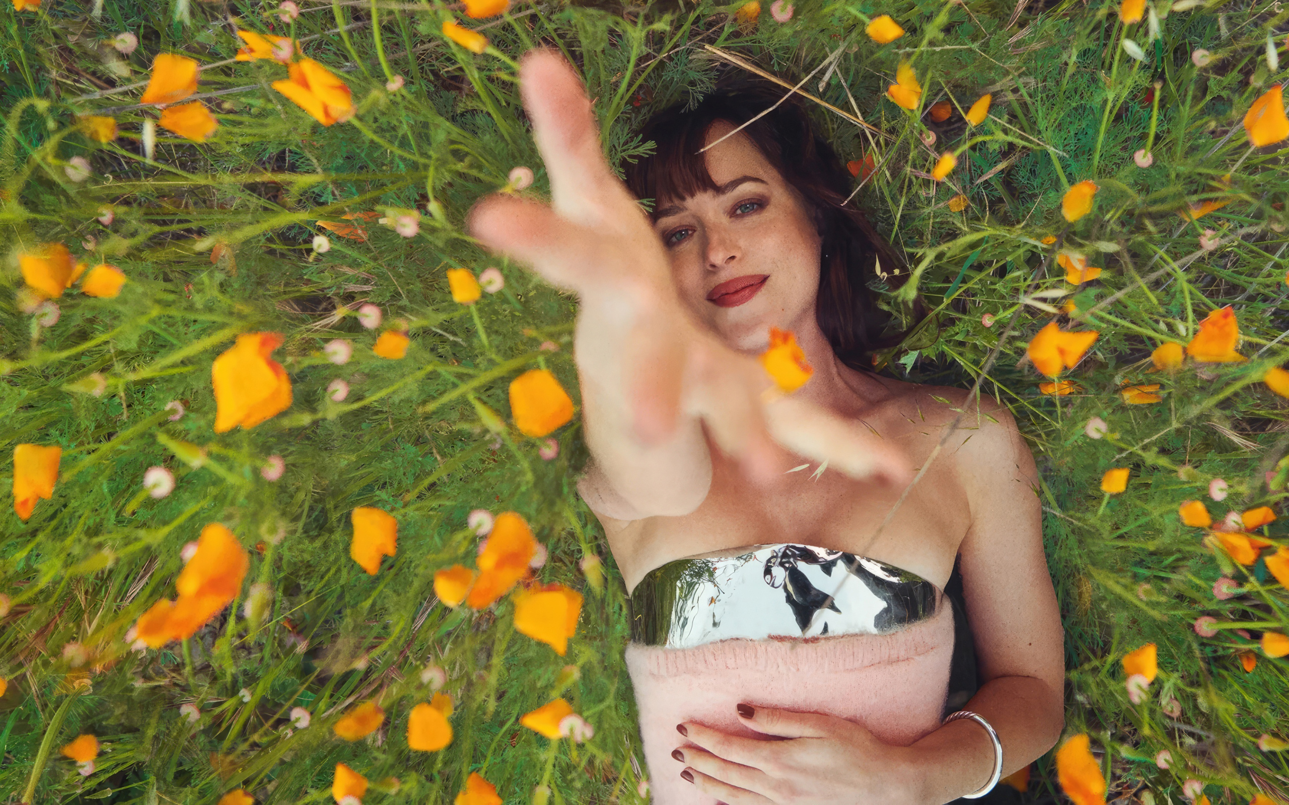 Американская актриса Дакота Джонсон лежит на траве с цветами