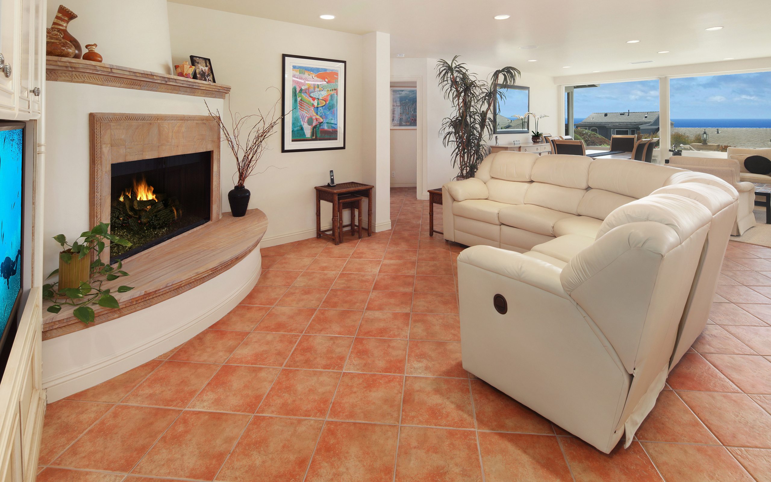 Красивый белый кожаный диван в гостиной с камином