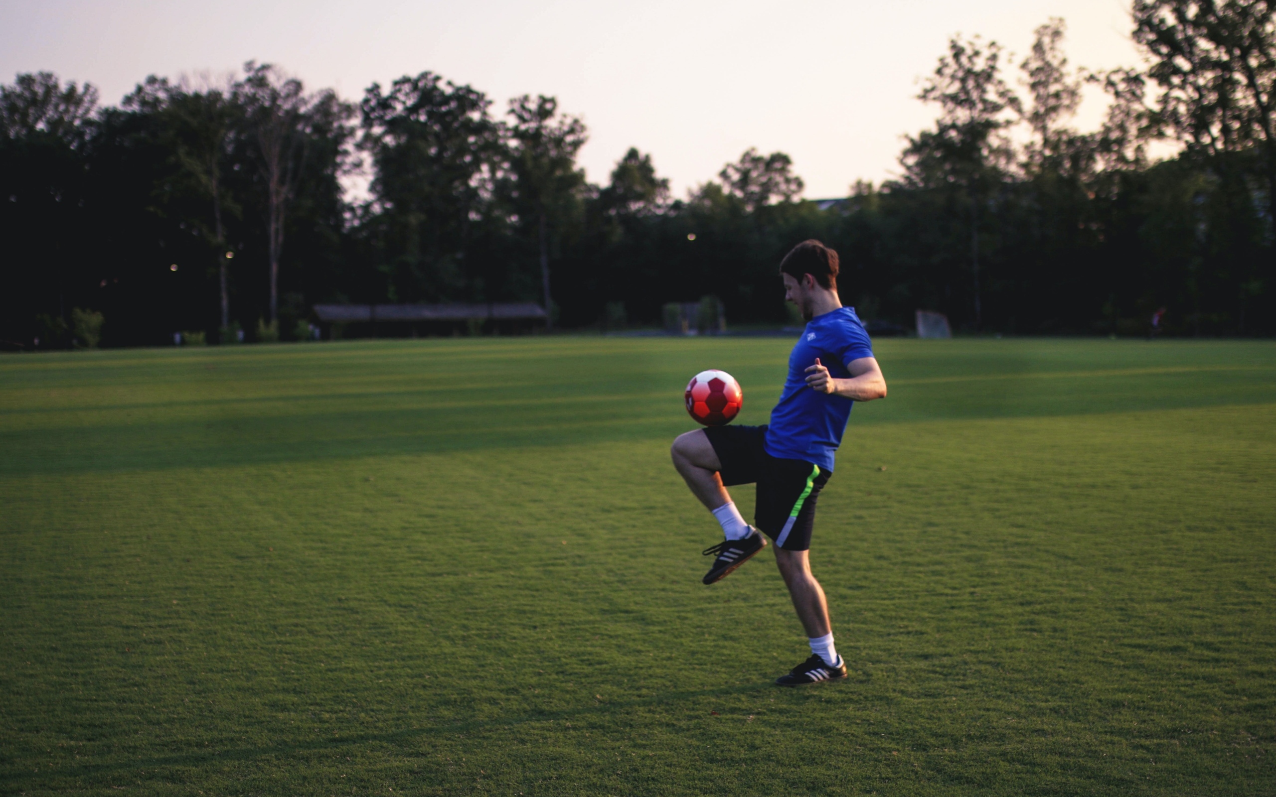 Мужчина футболист с мячом на поле