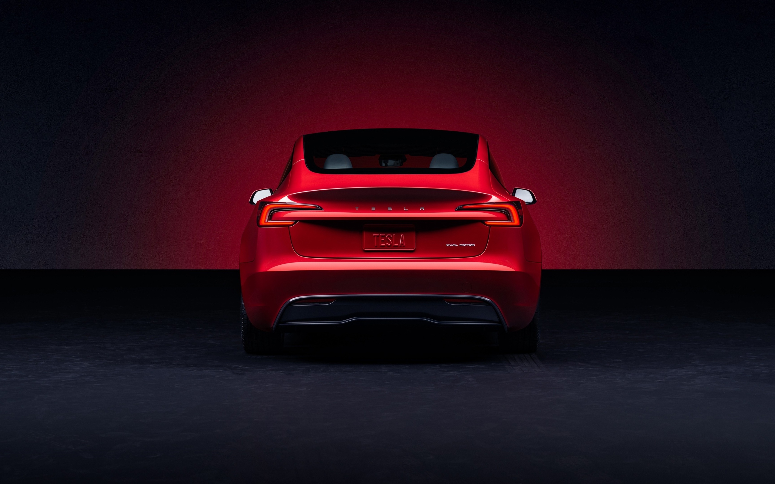 Красный автомобиль Tesla Model 3 2023 года вид сзади