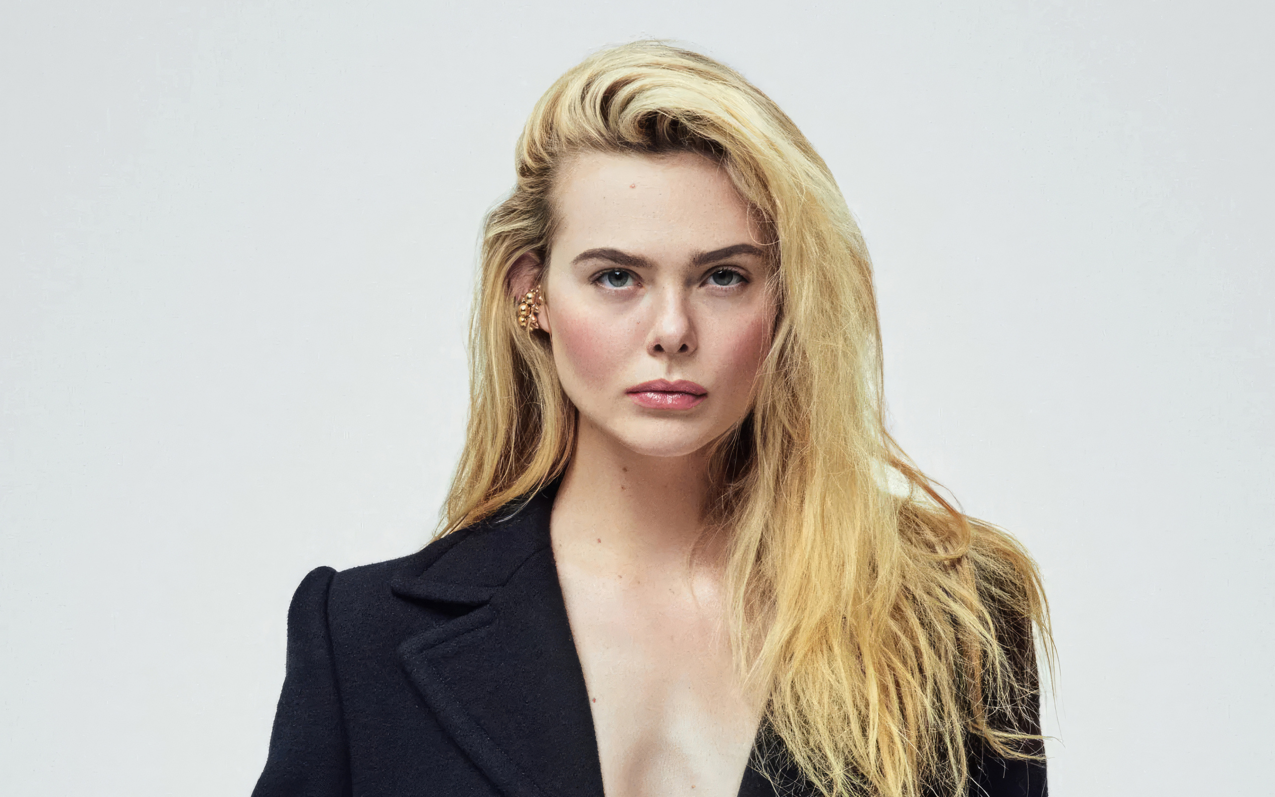 Серьезная девушка актриса  Эль Фэннинг на сером фоне