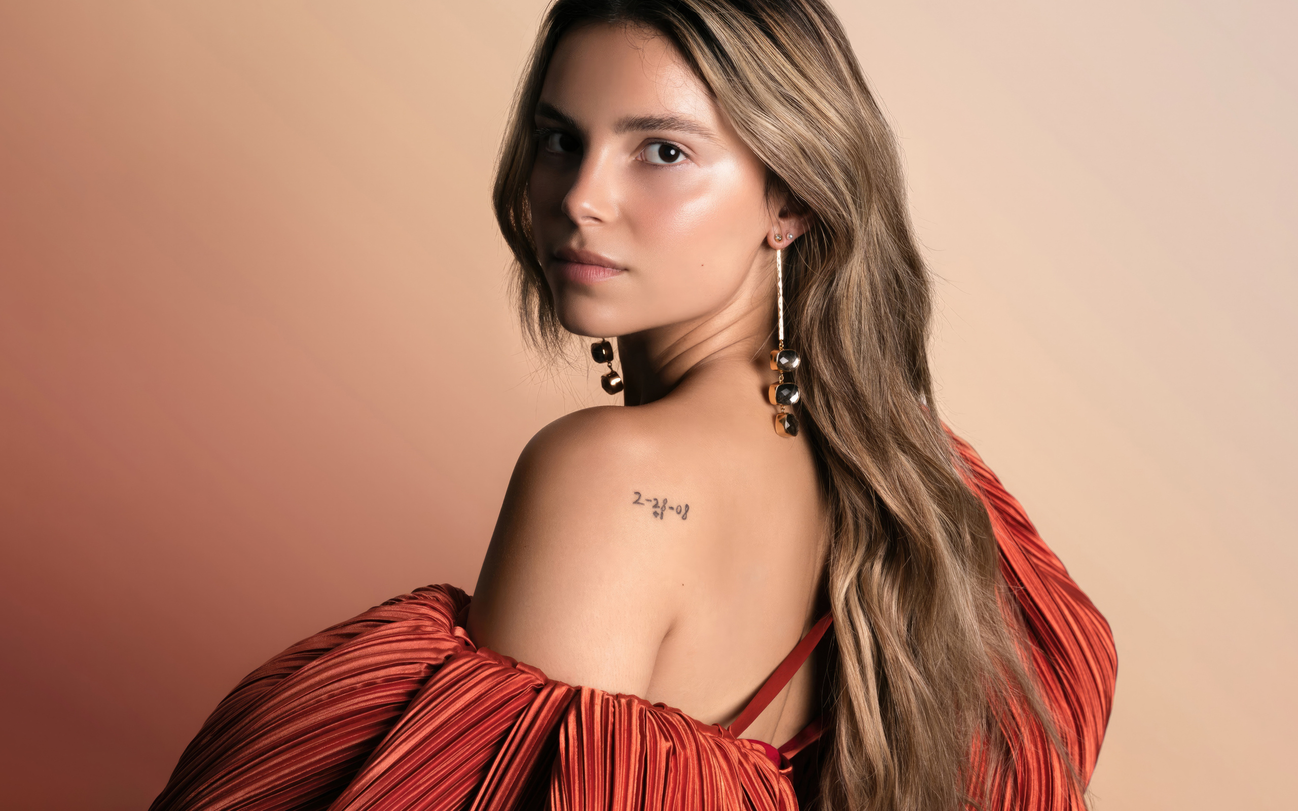 Стильная девушка актриса Инде Наварретт на розовом фоне