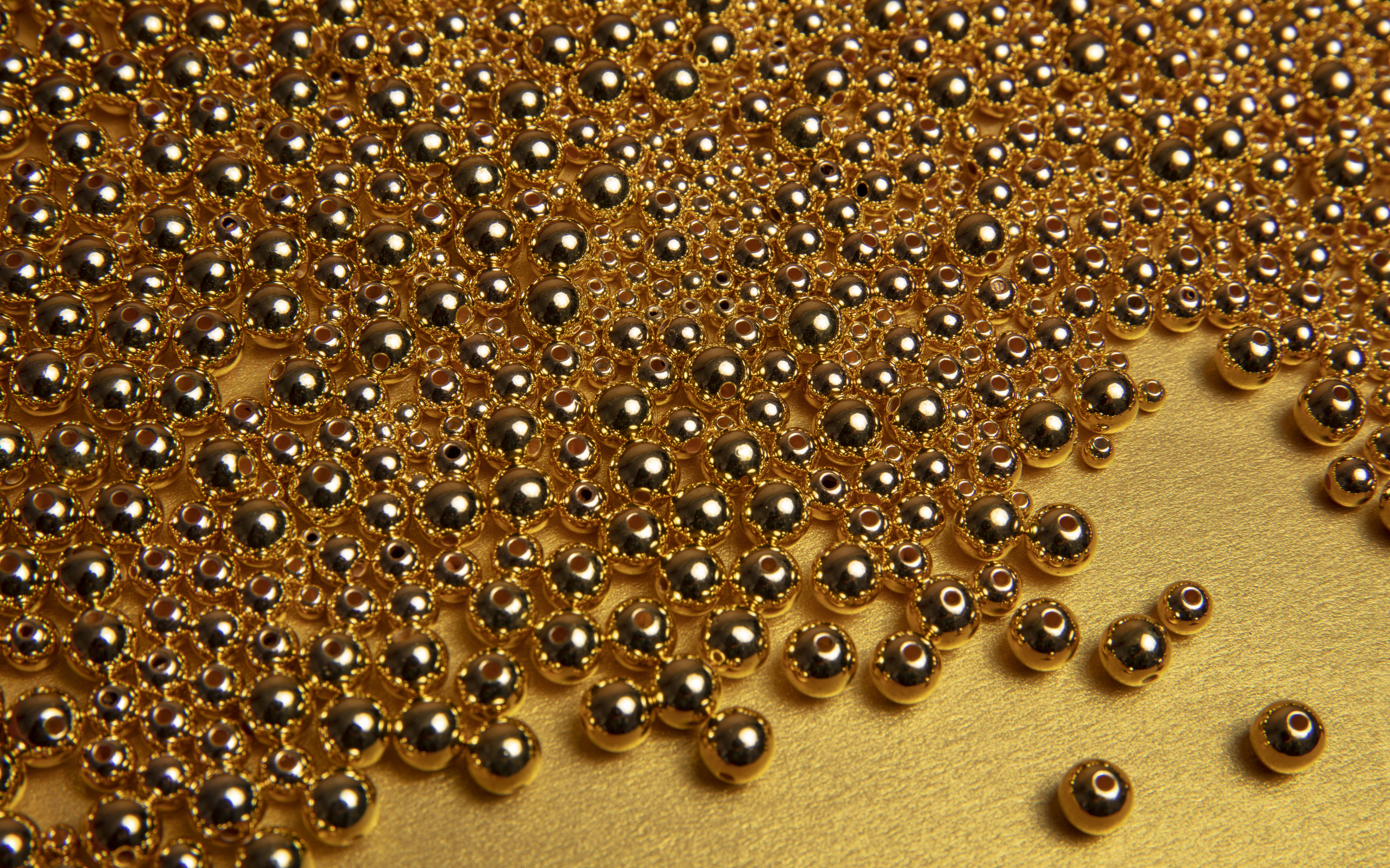 Много золотых бусин на желтом фоне